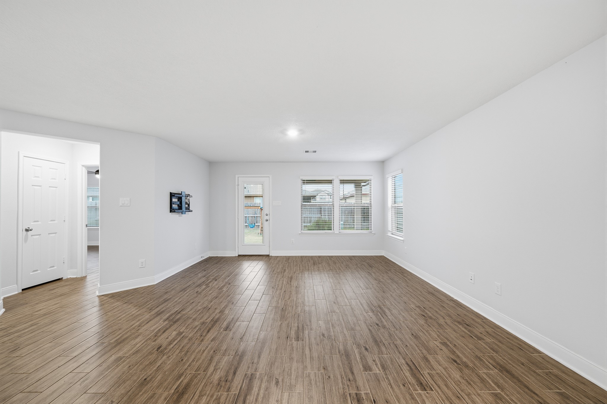 Discover the inviting charm of this spacious living area, bathed in natural light and featuring elegant flooring that seamlessly blends style and comfort.