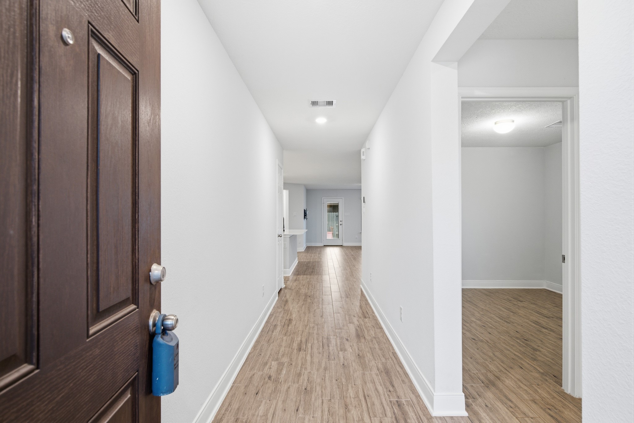 Step into this inviting entryway, featuring sleek flooring and a bright, open corridor that warmly welcomes you home.