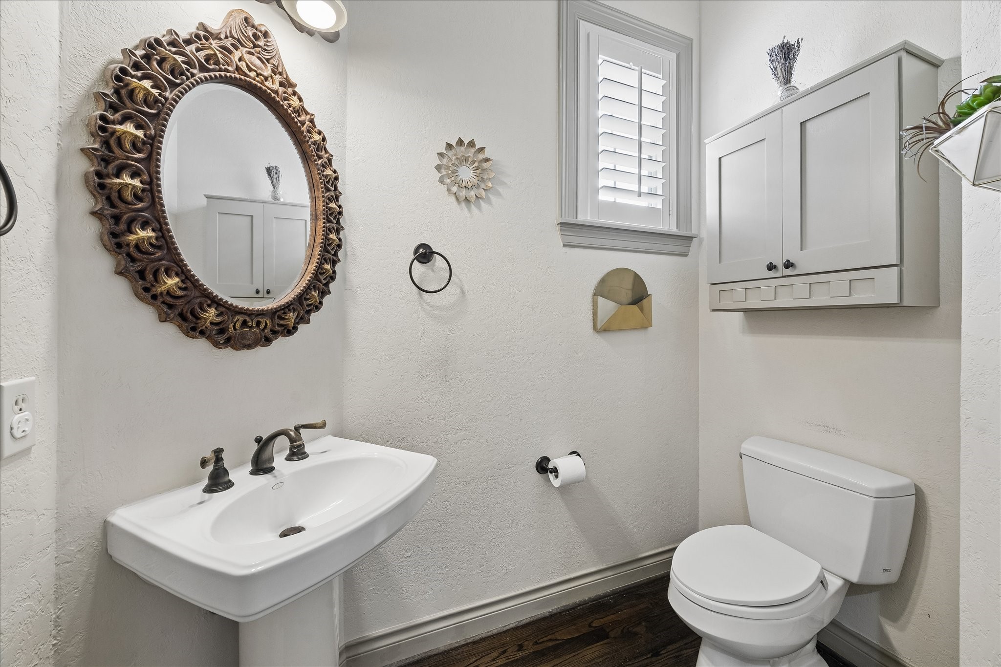 Conveniently located 1st floor powder bath positioned off entry & formal living room. Features pedestal sink w/ decorative vanity mirror & lighting above, built-in storage above toilet, and privacy window w/ plantation shutters. A thoughtfully located bath for guests.