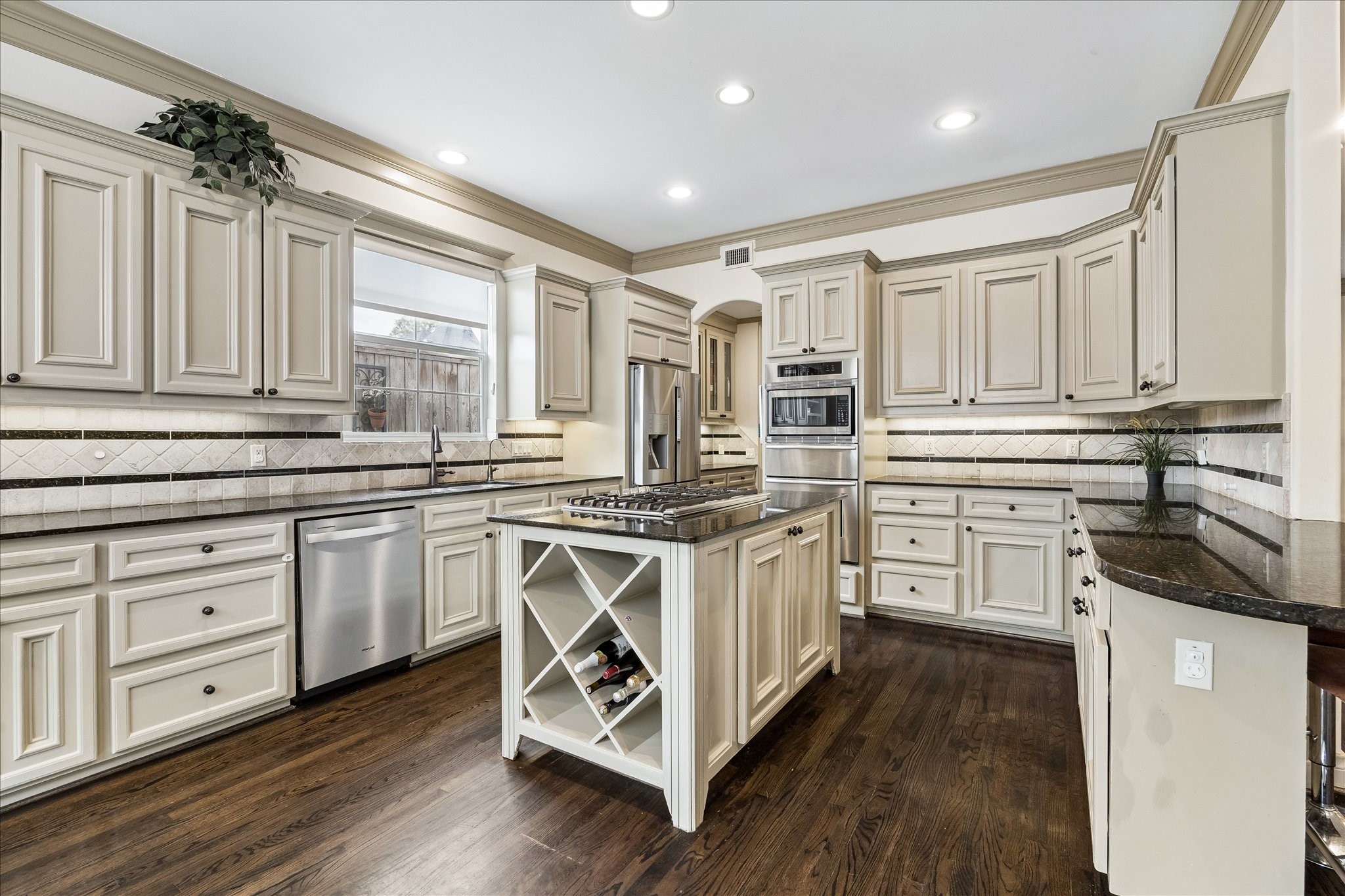 Fabulous kitchen centered around the island, which features a stainless steel LG 5-burner gas cooktop, cabinetry & wine storage below. Granite countertops, abundant cabinetry & under-cabinet lighting create a beautiful & highly functional heart of the home.