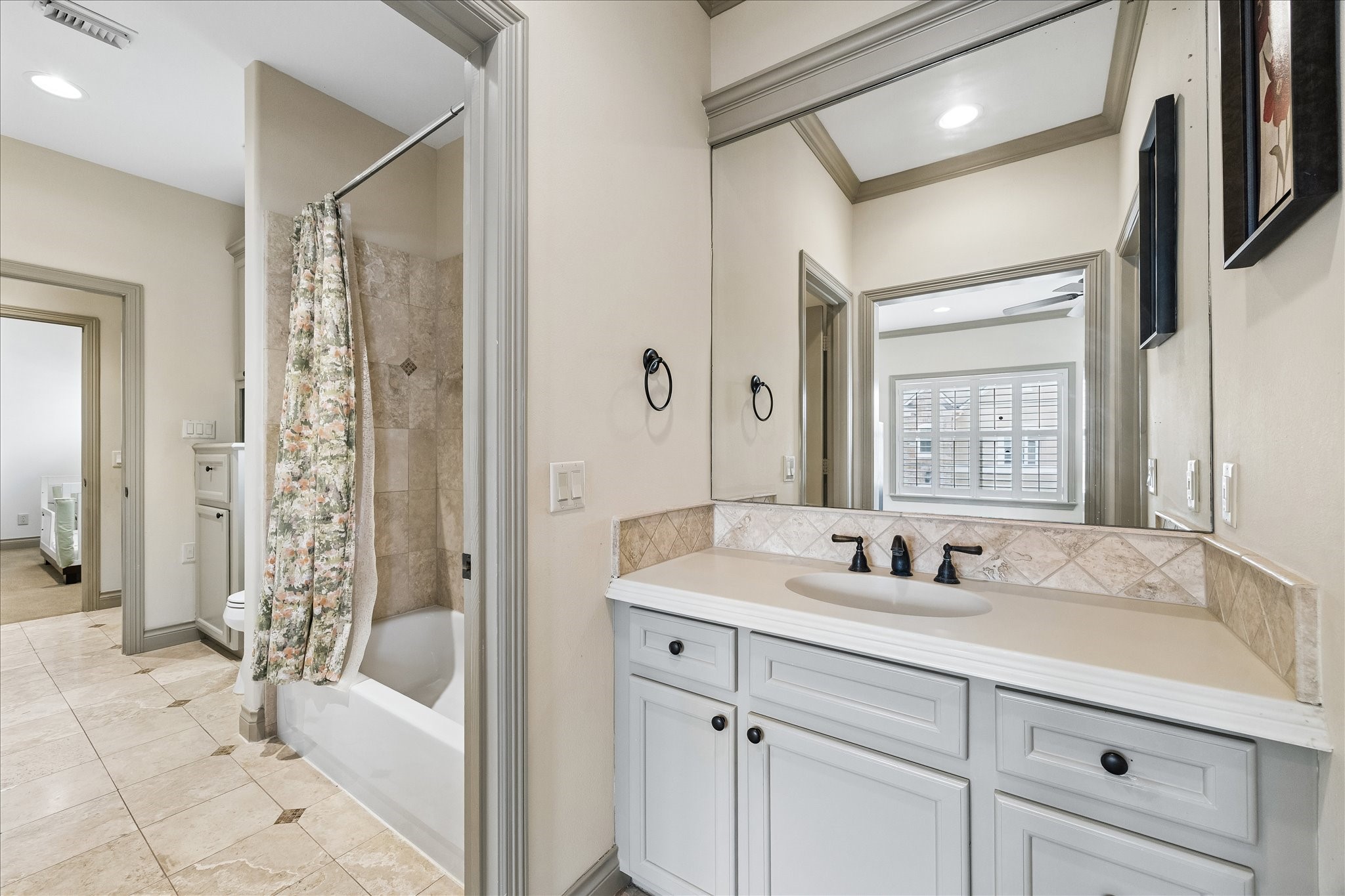 Thoughtfully designed Jack & Jill bath connecting the two 2nd floor secondary bedrooms. Each bedroom features its own private vanity area & separate walk-in closet w/ built-in hanging & shelving, providing excellent storage & privacy. The shared bathing area is conveniently positioned between the two bedrooms w/ a tub/shower combo.