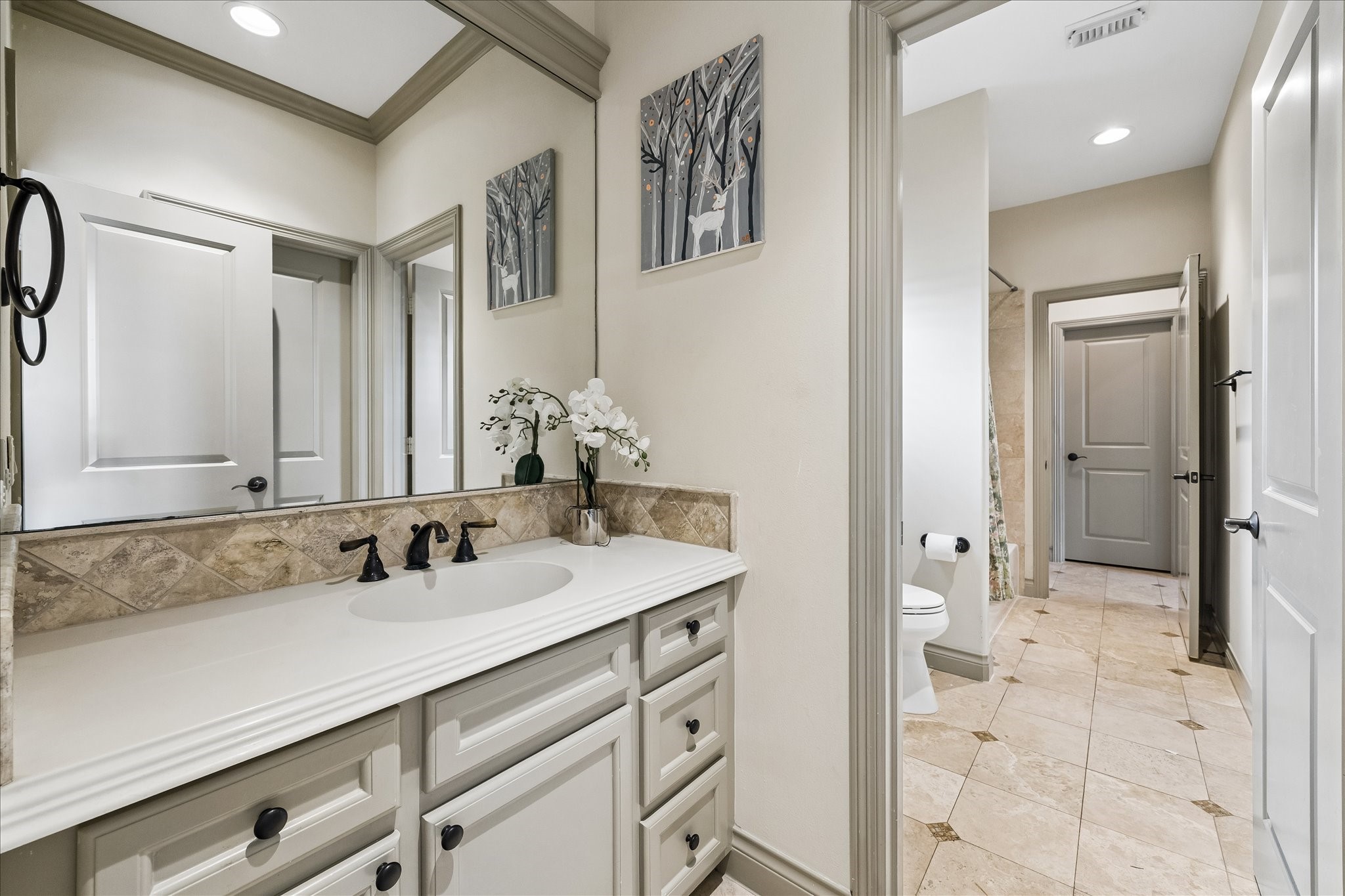 Another view of the Jack & Jill bath highlighting the one of the two private vanity spaces that caters to each secondary bedroom (w/ a shared bathing area w/ tub/shower combination & toilet). This functional layout allows both secondary bedrooms to enjoy their own private vanity spaces while sharing the separate bathing area, ideal for family or guests.