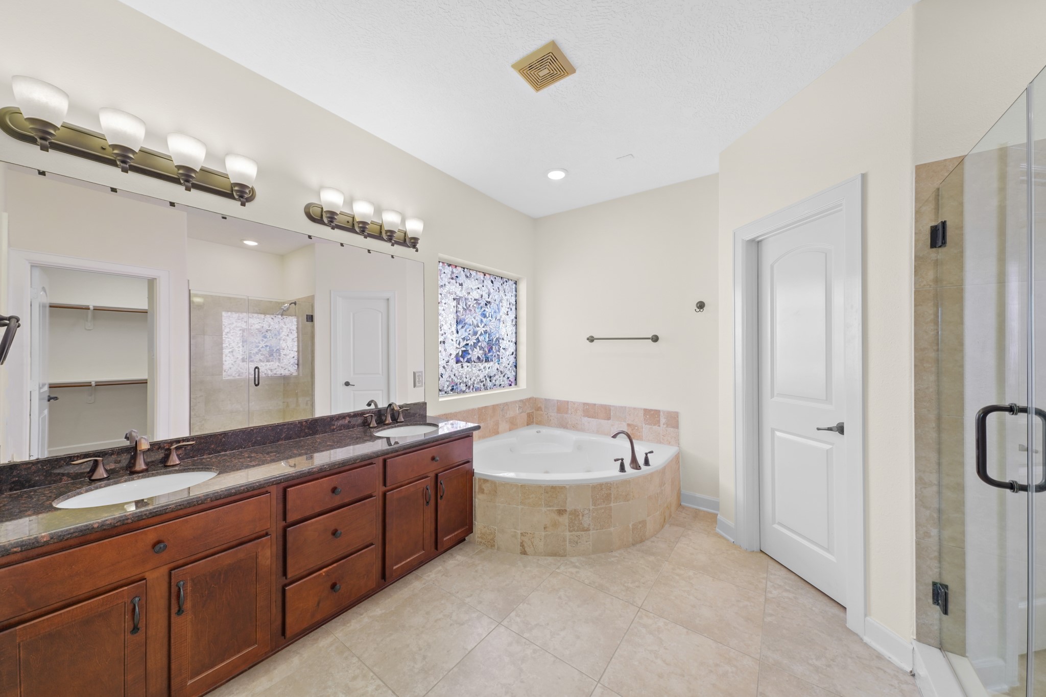 Welcome to your very own retreat! This master bath boasts dual sinks, granite countertops and backsplash, elegant lighting, and tile floors.