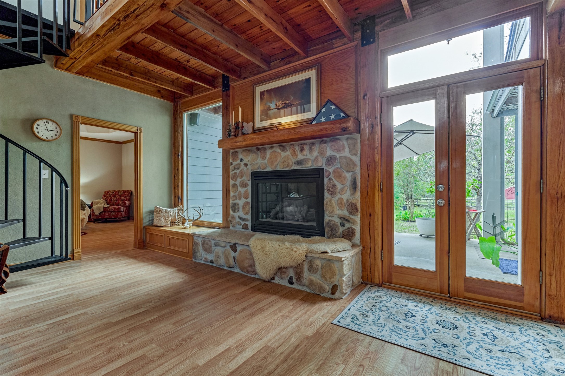Large gas log -  stone fireplace with large custom windows and double doors to back covered patio area overlooking acreage.