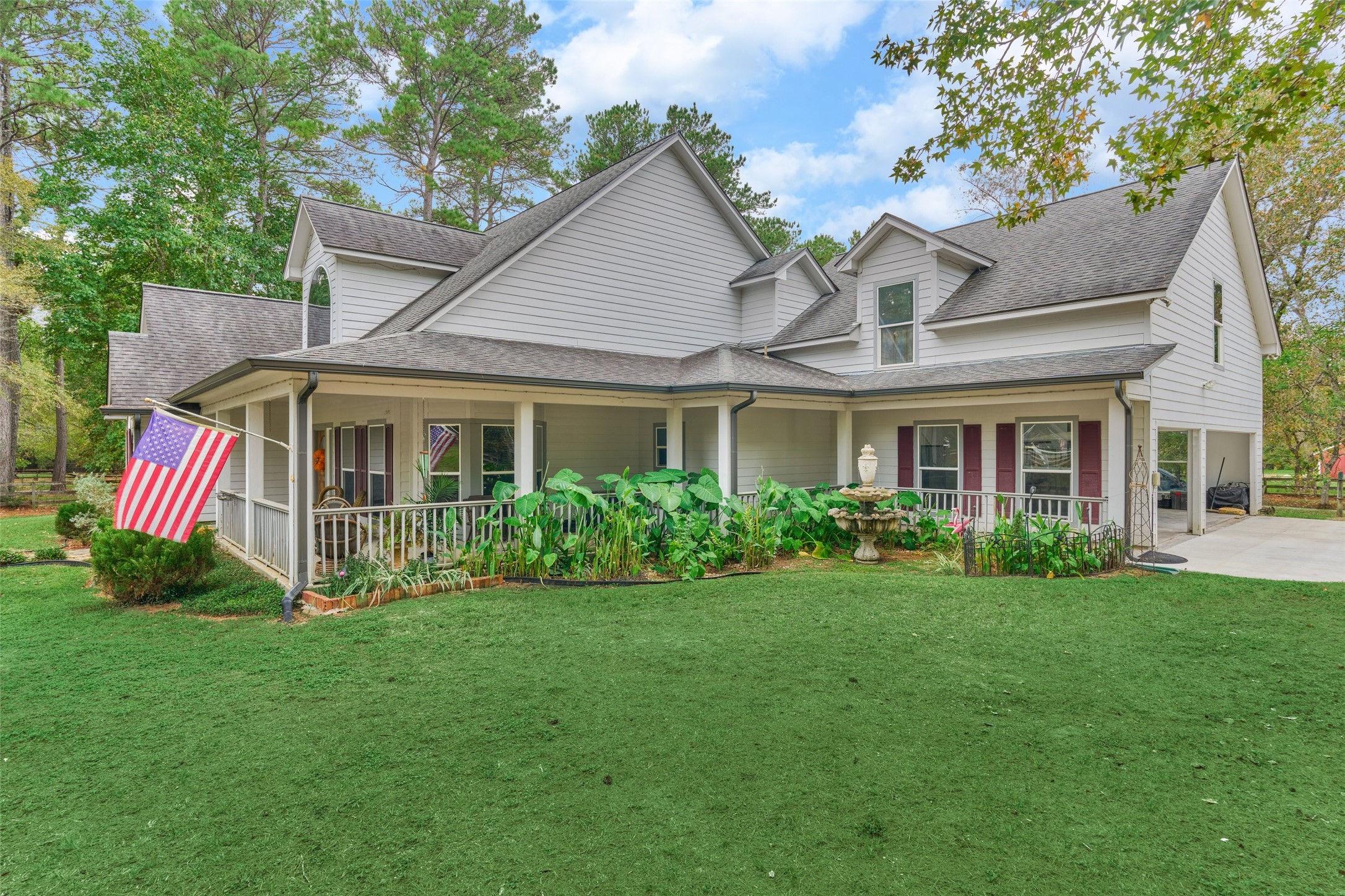 Side view of the large wrap around porch with great landscaping and fountain. Side view of the large wrap around porch with great landscaping and fountain.