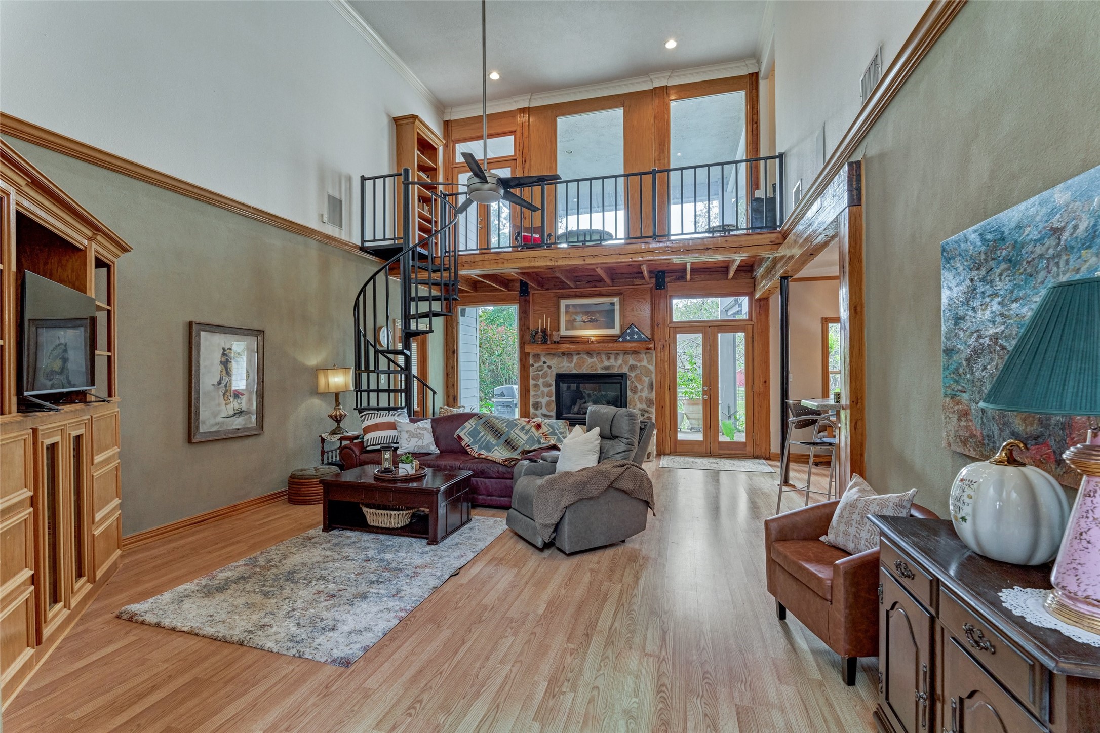 Landing at the top of spiral staircase with view of property and one of two balconies, leading to abundant attic storage and flex unfinished space waiting for your plans!