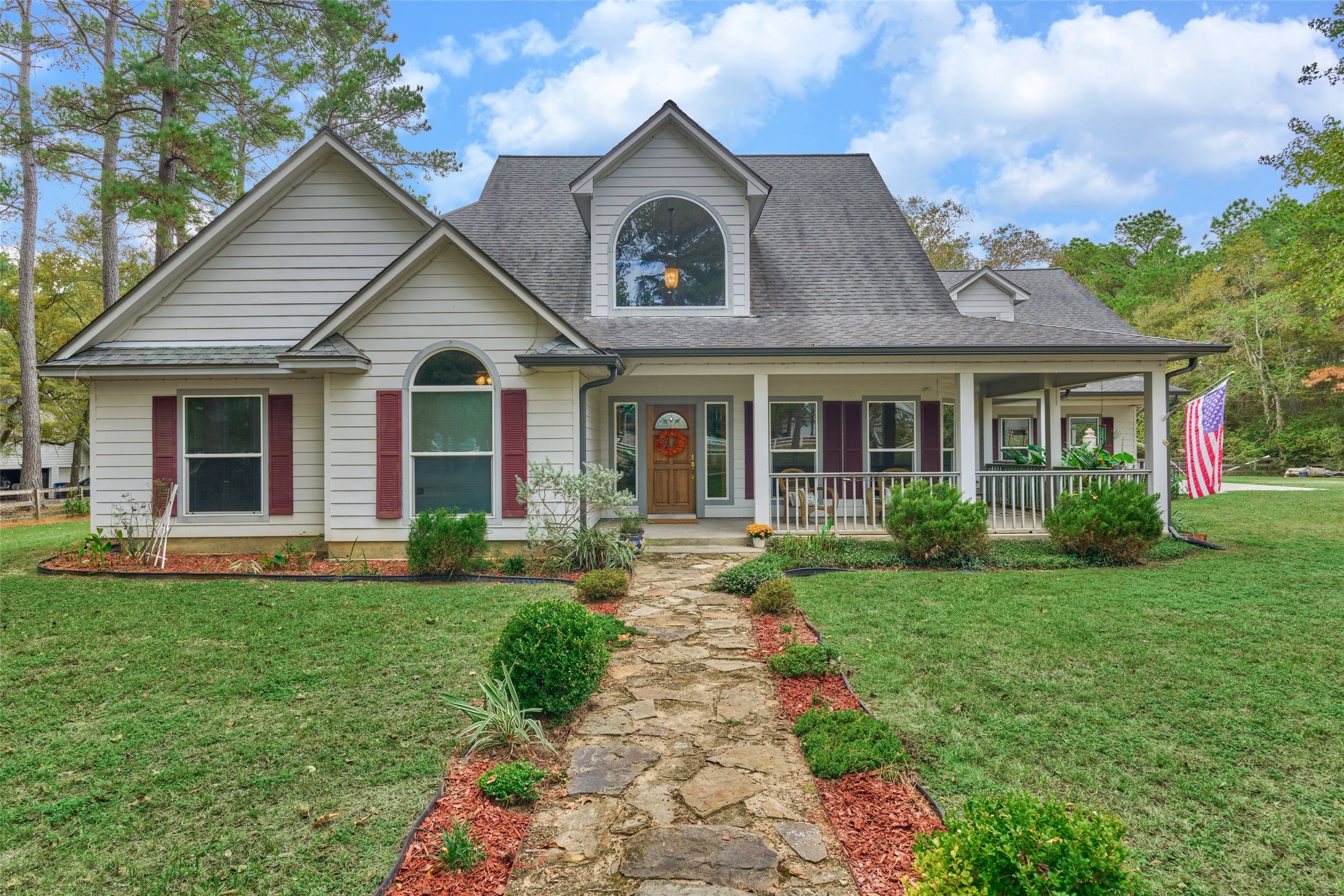 Beautiful two-story custom home with inviting front porch, manicured landscaping, and a welcoming stone pathway, nestled among mature trees. Beautiful two-story custom home with inviting front porch, manicured landscaping, and a welcoming stone pathway, nestled among mature trees.