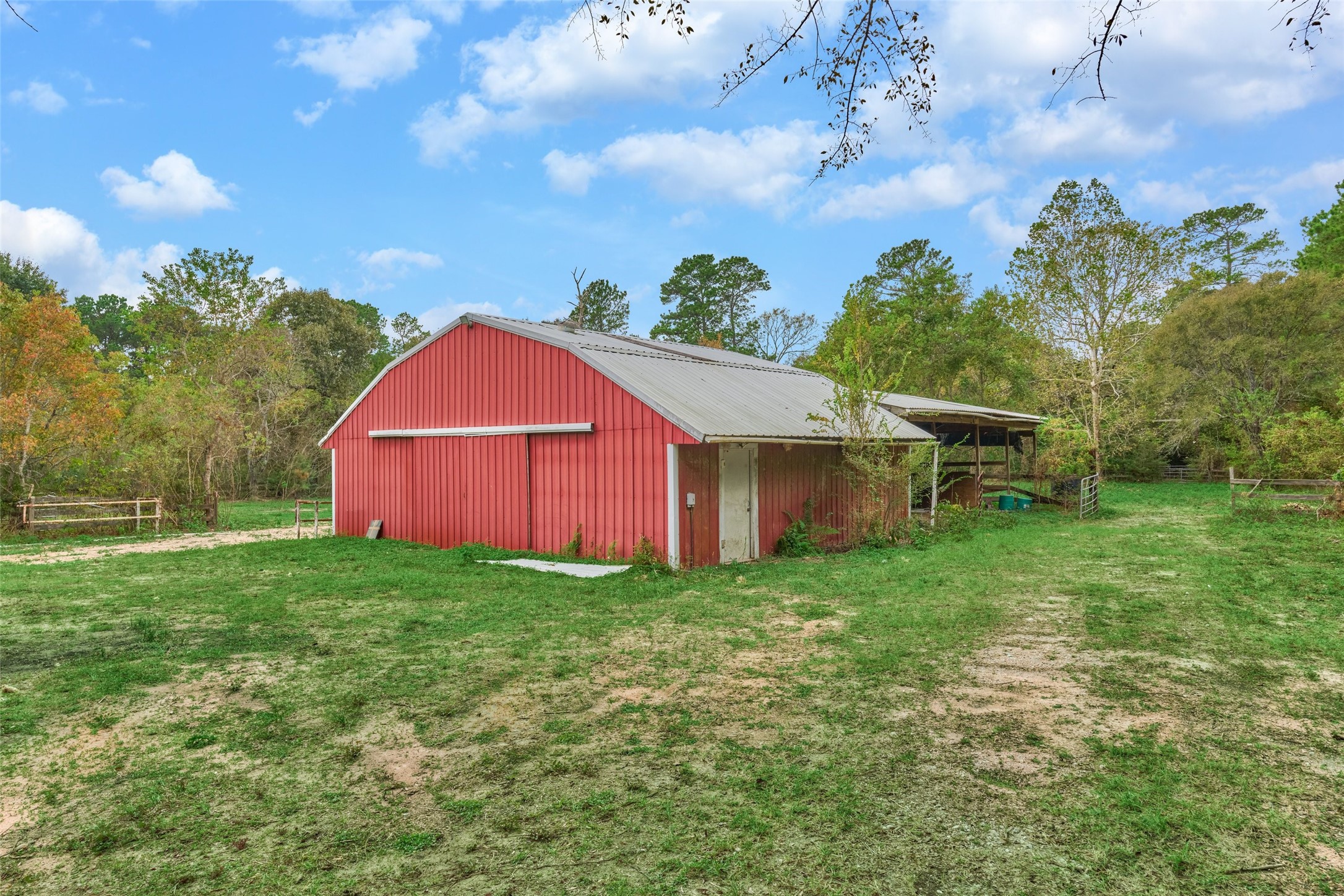 Large Pole Barn and wooden barn behind with three horse stalls in back
