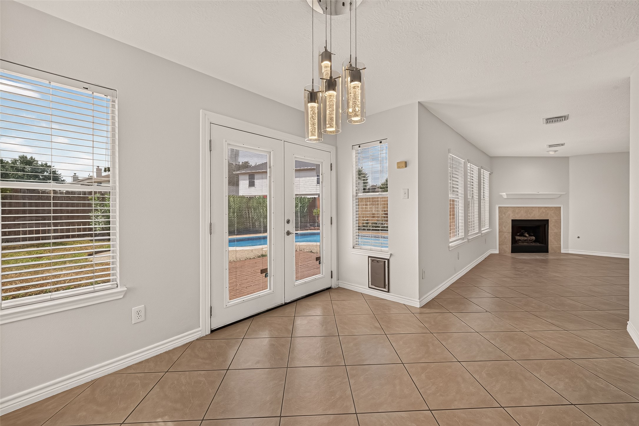 Start the day with a view of the pool from this bright breakfast area, then step through the French doors to enjoy the patio, with blinds across all of the windows.