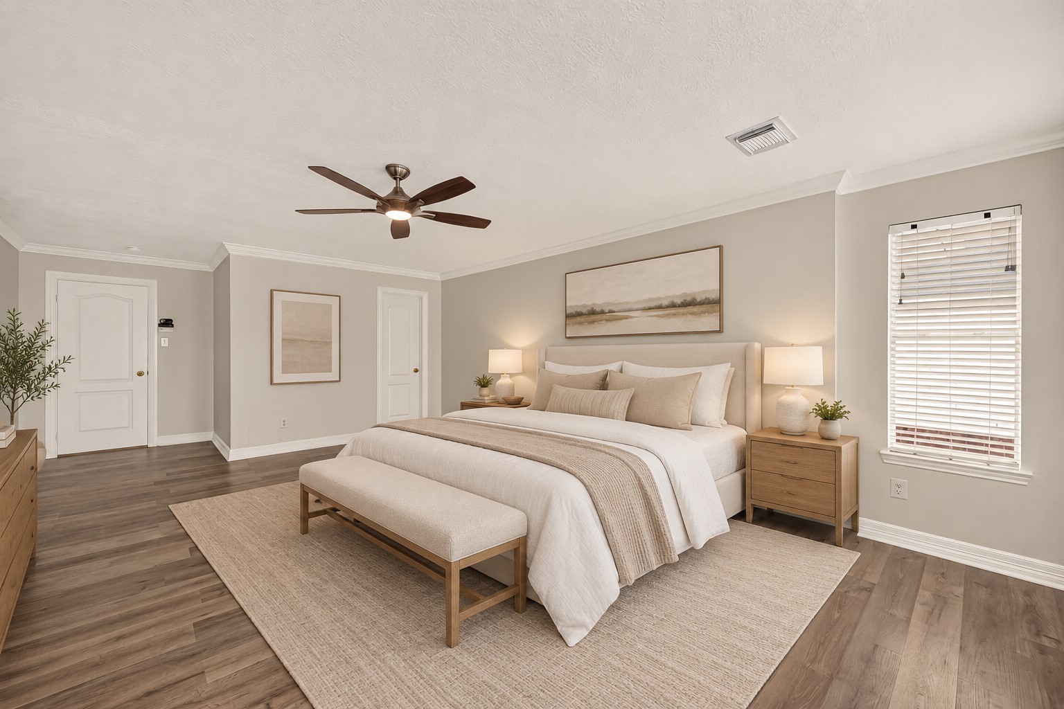 Spacious upstairs primary bedroom with vinyl flooring, crown molding, and a ceiling fan. Virtually staged.