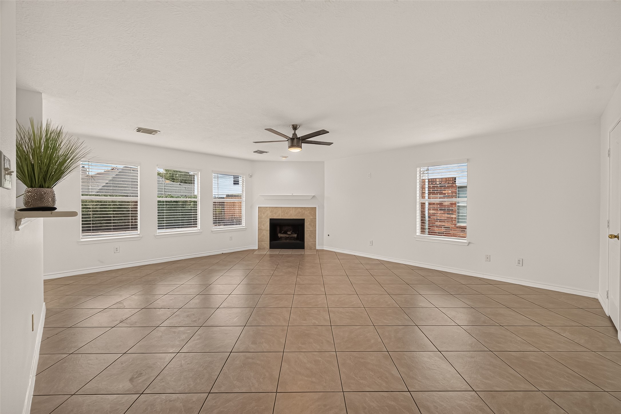 Gather around the fireplace in this spacious family room, where four windows bring in plenty of natural light and tile flooring makes everyday living easy.