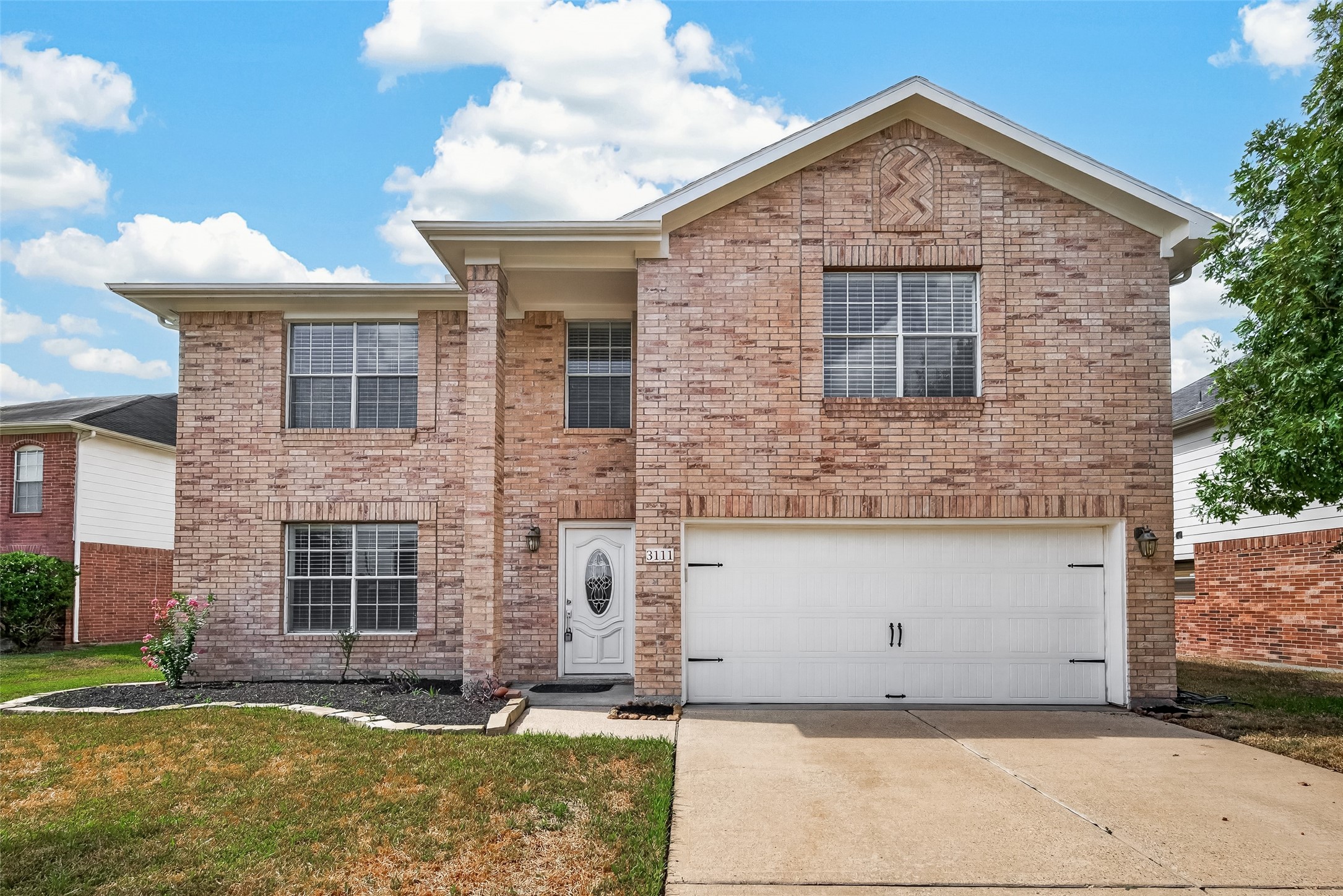 Welcome home to a charming brick exterior with distinctive gable brickwork, a double-wide driveway, and a two-car garage.