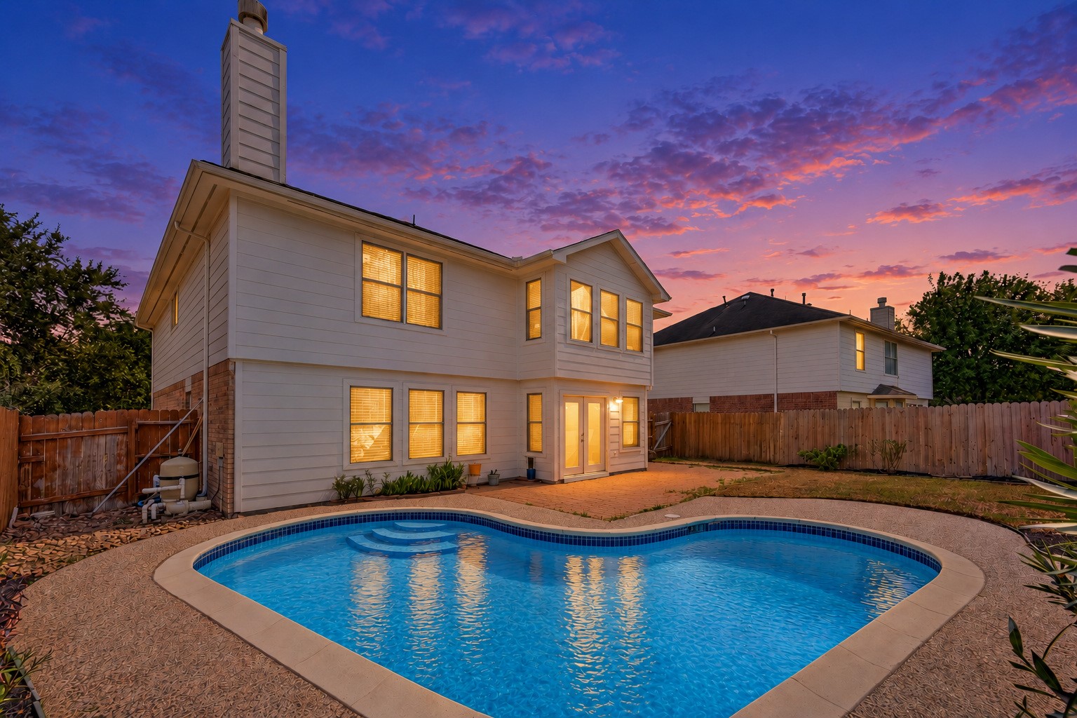 Picture evenings by the pool with the patio just steps from the back door. NEW ROOF 2026 POOL REFINISHED 2026 **Digitally edited twilight image.