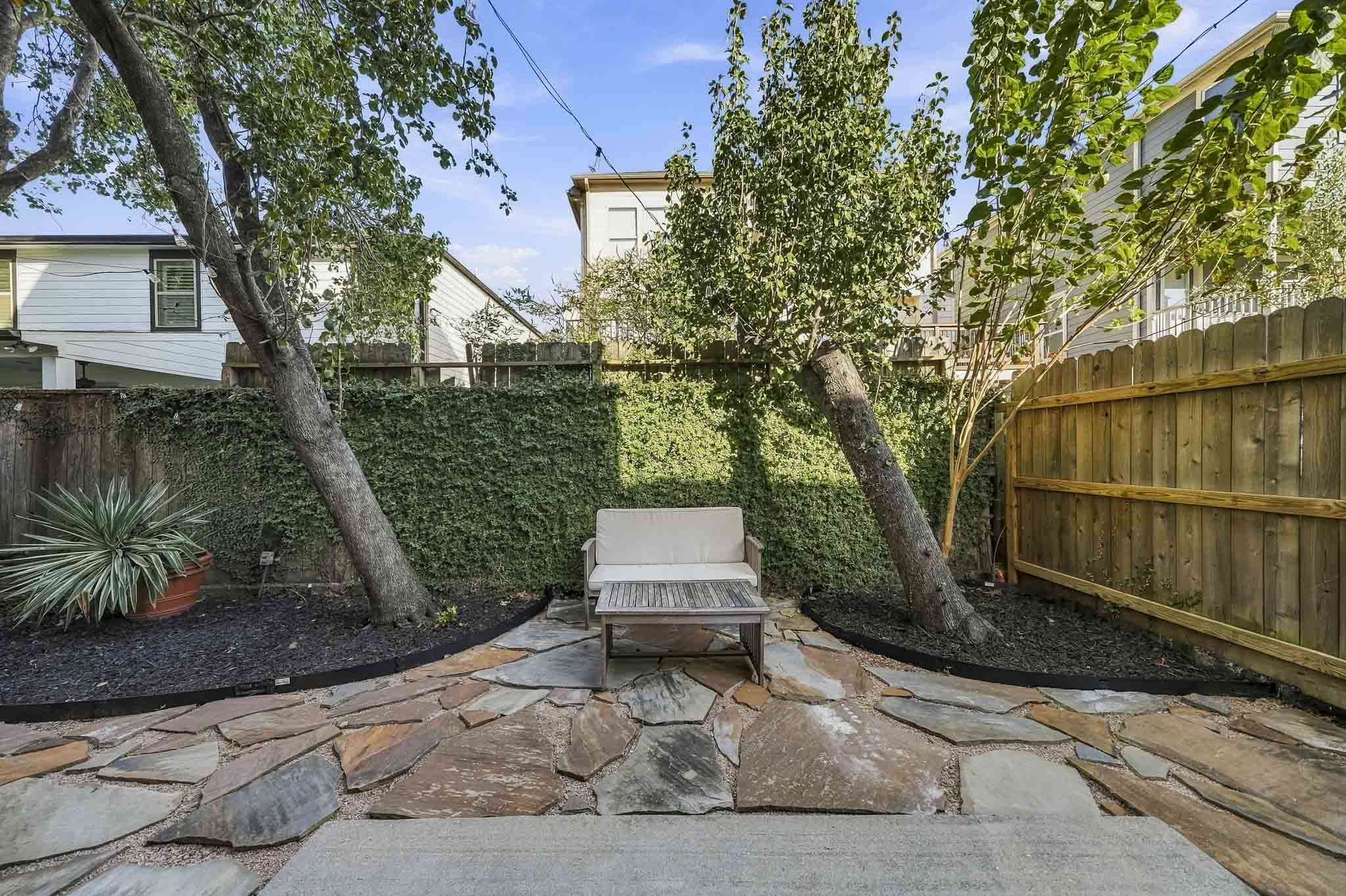 Surrounded by mature trees, this private side patio offers a charming outdoor setting for al fresco dining, weekend gatherings or peaceful moments beneath the canopy of shade.