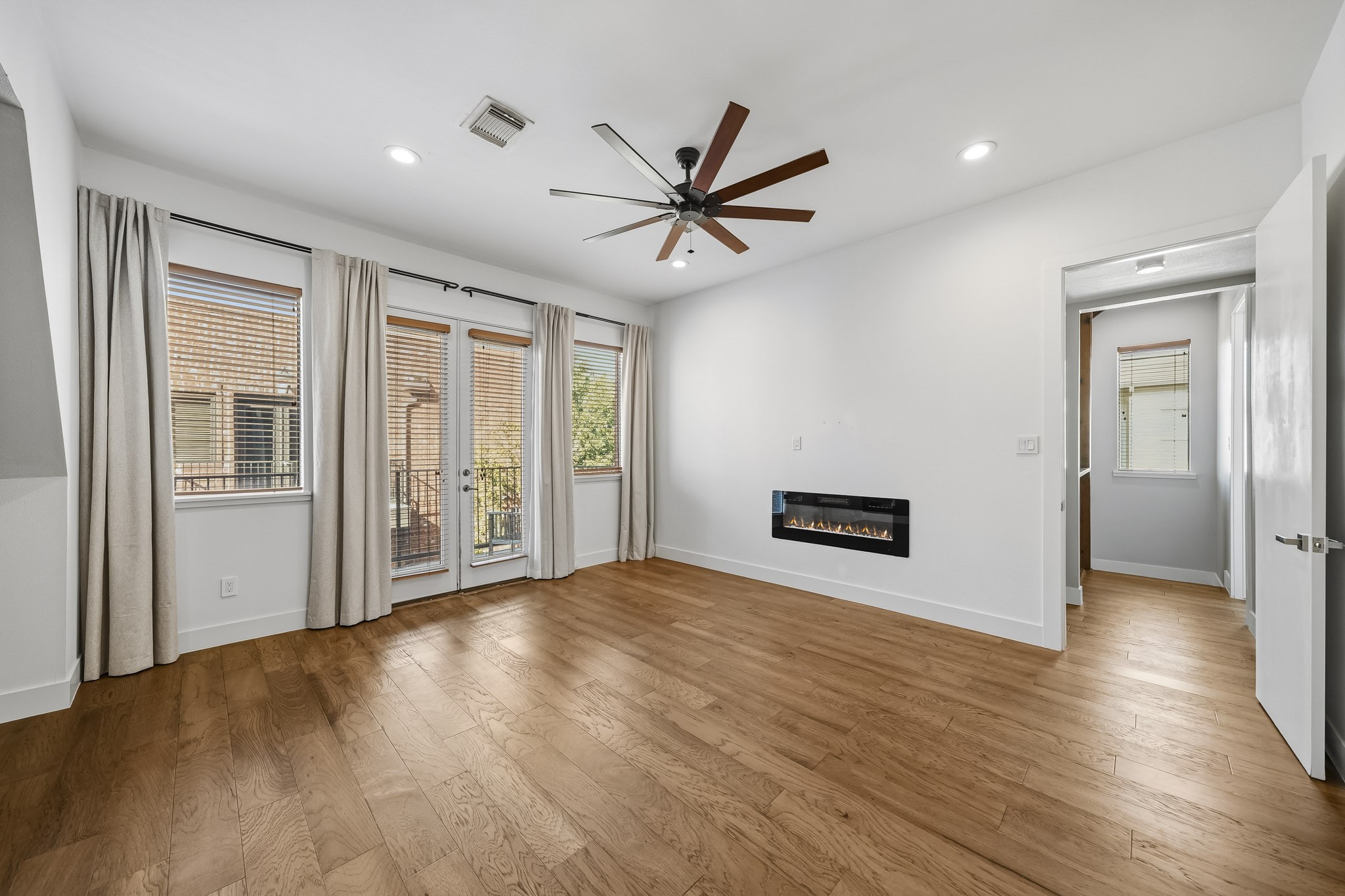 An impressive 8-foot patio door opens from the primary suite to a private balcony, creating a seamless connection to the outdoors. A sleek, linear electric fireplace adds warmth and contemporary elegance, enhancing the suites luxurious ambiance.