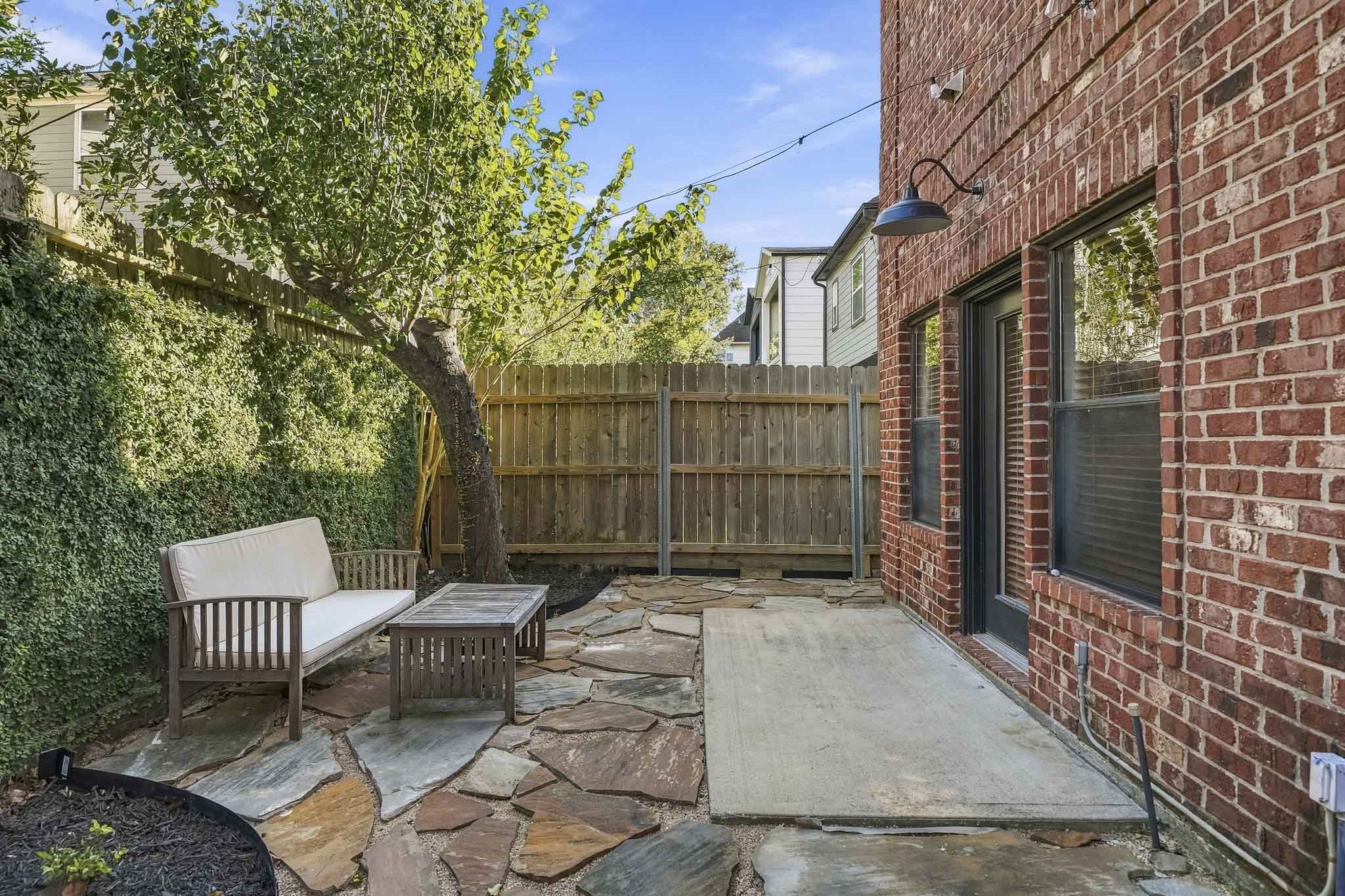 A gated entry beside the front door provides private access to the side patio, creating a secluded outdoor space just steps from the home's entrance.