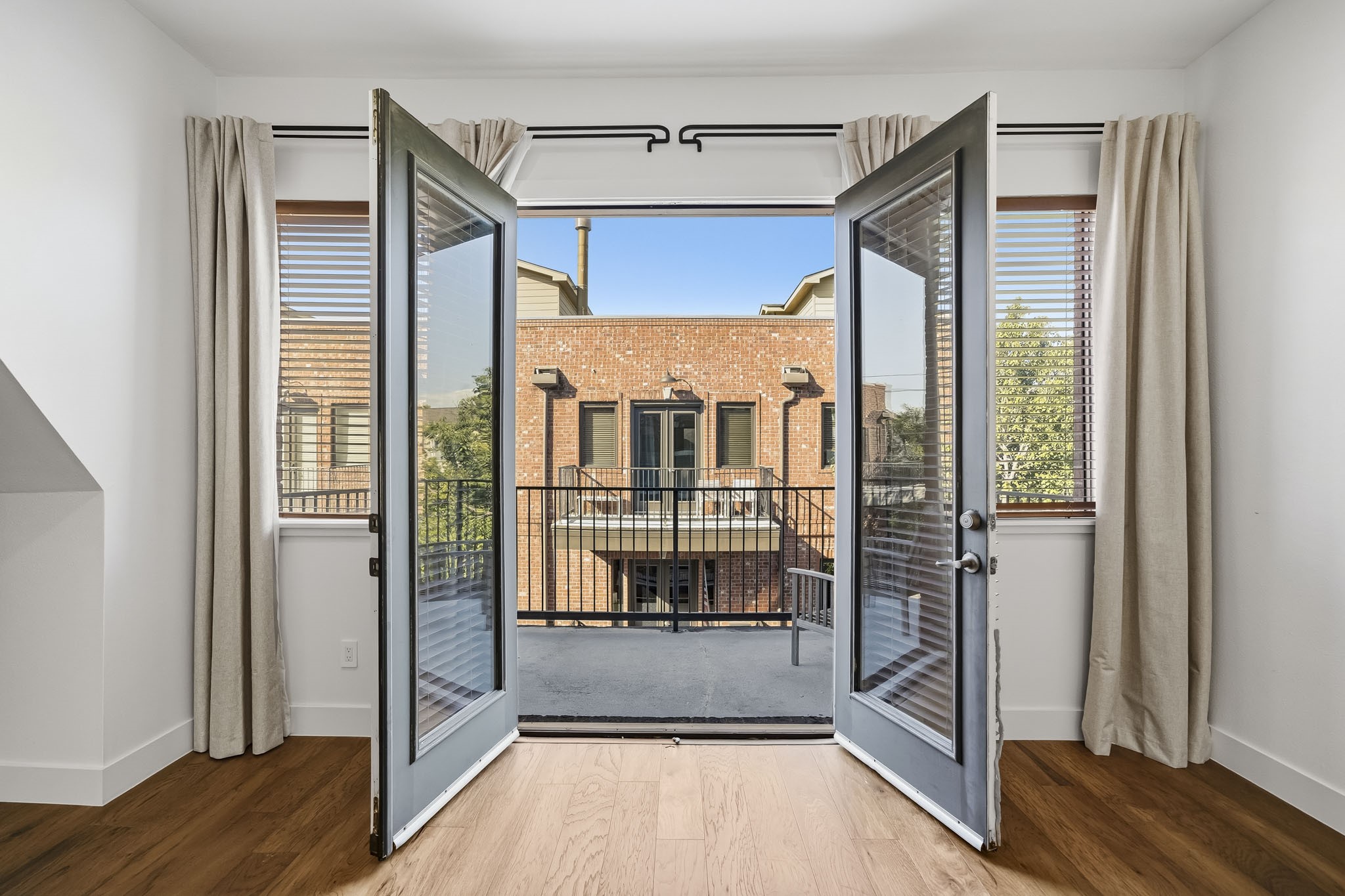 Elegant doors open from the third-floor primary suite to a private balcony, creating a seamless extension of the living space and an inviting outdoor retreat for morning coffee or relaxing at the end of the day.