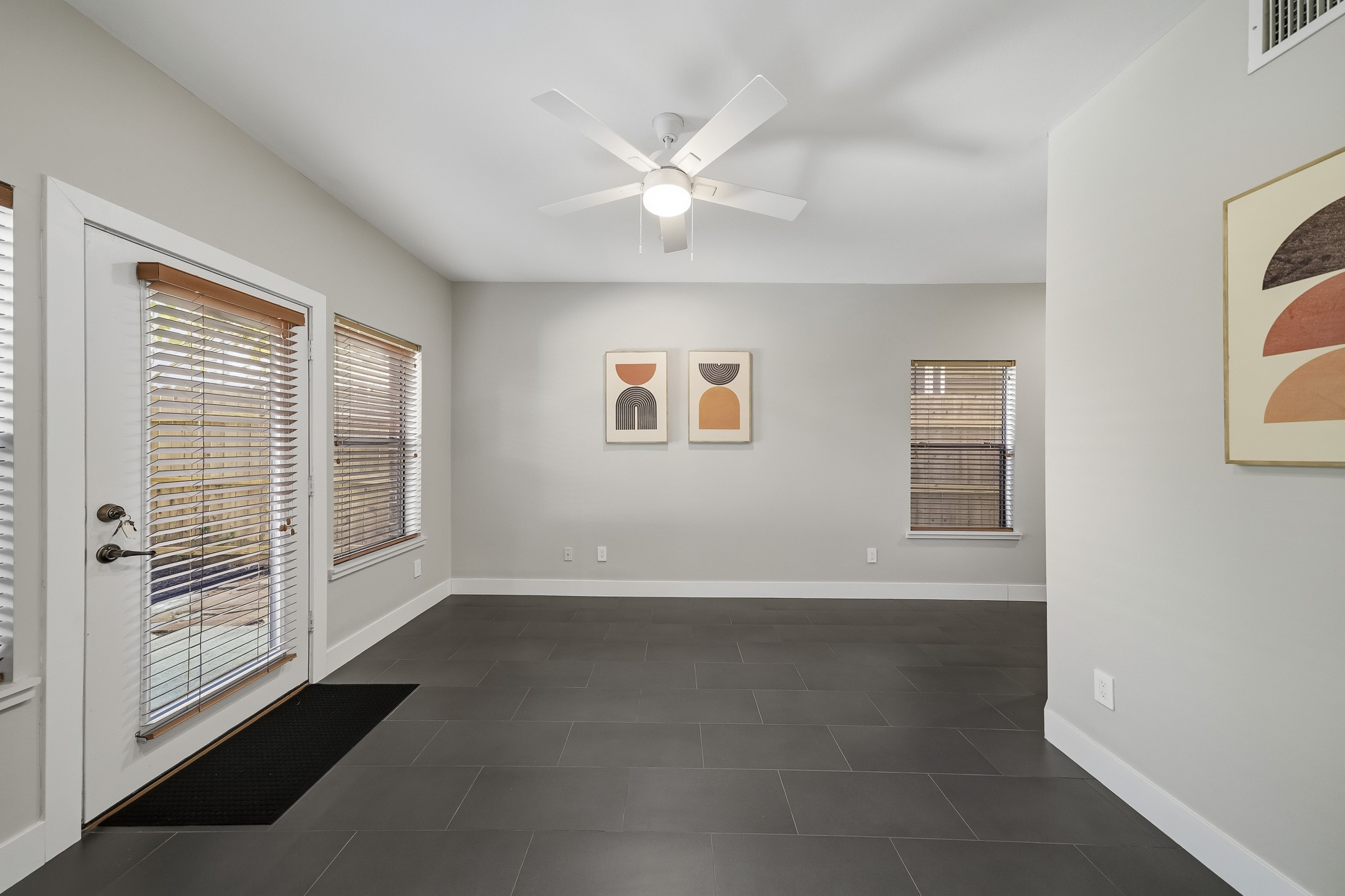Located on the first floor, the third bedroom features tile flooring, recessed lighting and a ceiling fan with an integrated light, offering a comfortable, versatile space with a clean, contemporary finish.