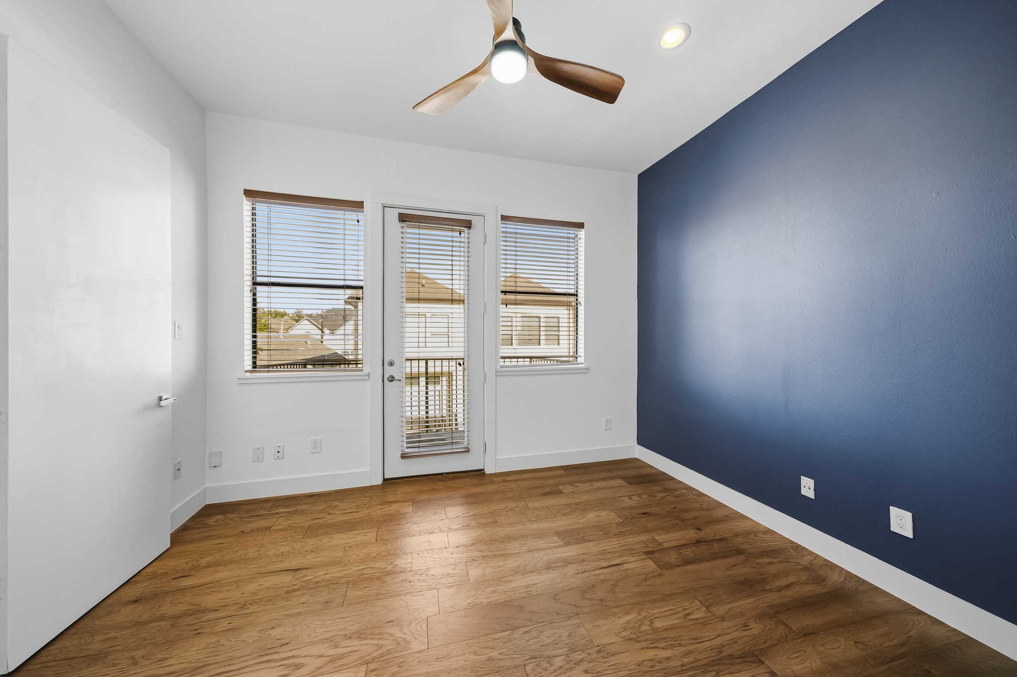 This beautifully appointed secondary bedroom features rich hardwood floors, recessed lighting and a ceiling fan with an integrated light. An impressive 8-foot door opens to a private outdoor patio, bringing in natural light and extending the living space outdoors.