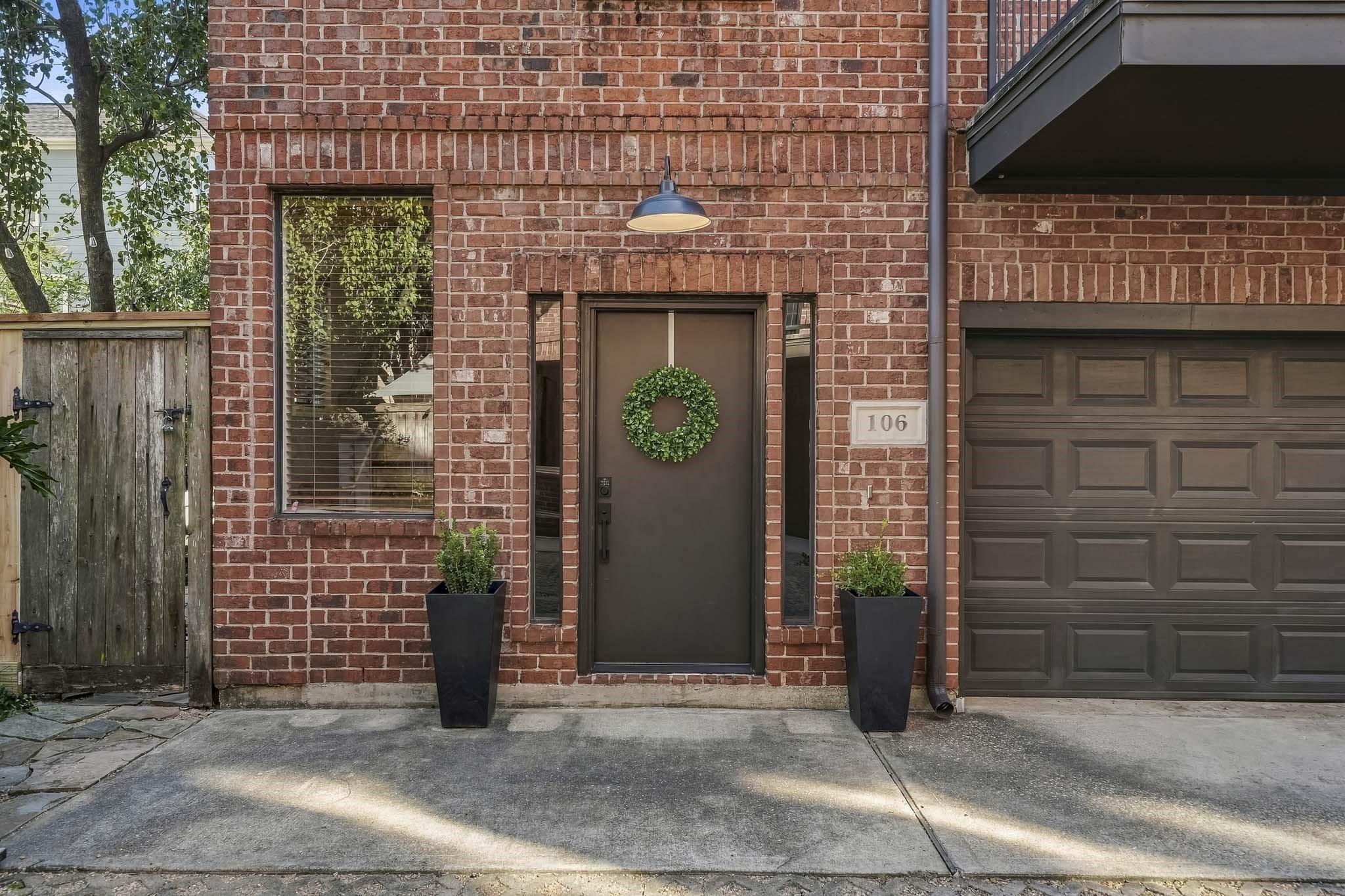 A new front door was installed in 2024 and is flanked by side lights with a two-car garage and an entry on the left to the spacious patio.