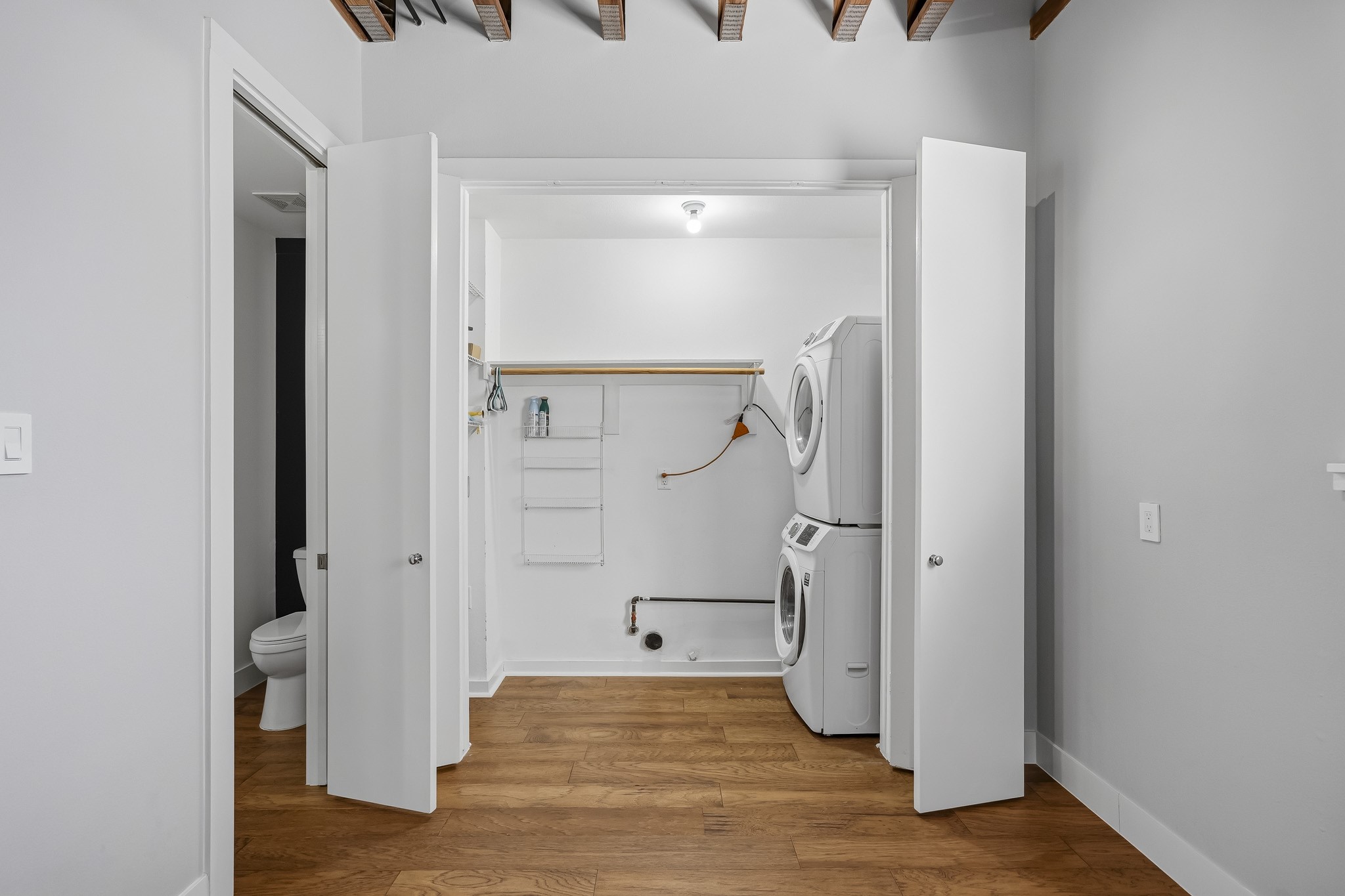 The dedicated utility room offers convenience and functionality, featuring both gas and electric dryer connections and a full-size Samsung stackable washer and dryer that convey with the home. A well-equipped space designed to simplify daily routines.