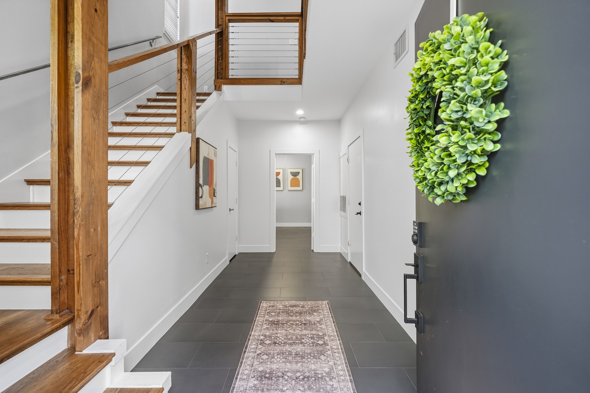 A tiled entry welcomes you into the home with rich wood stair treads and an open staircase extending to the fourth floor create a striking architectural feature, while the soaring ceiling enhances the sense of openness and vertical grandeur throughout the home.