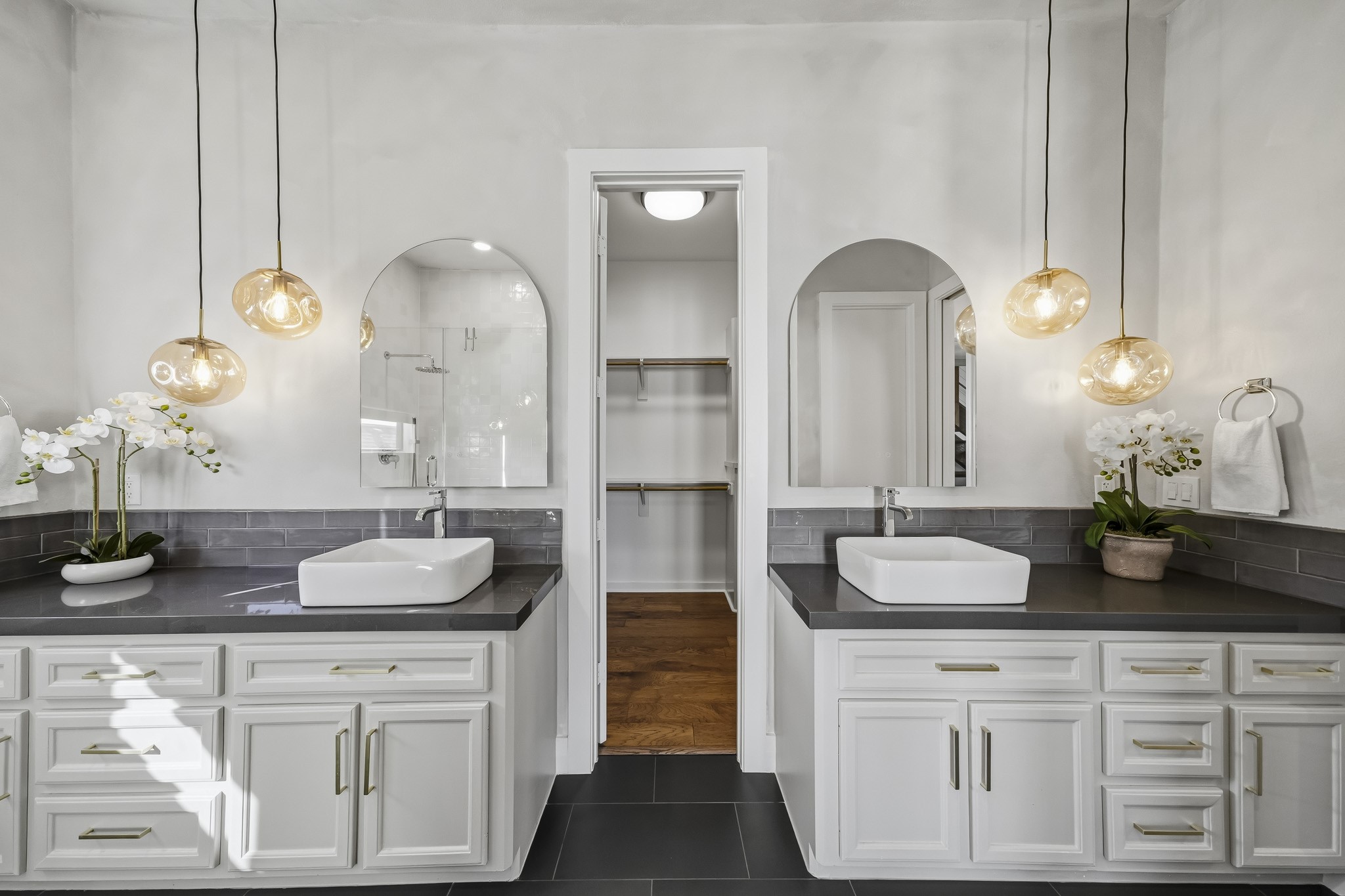 Remodeled in 2025, the beautifully appointed primary bath showcases elegant granite countertops, a classic subway tile back splash and dual vessel sinks, creating a sophisticated space with a touch of modern luxury.