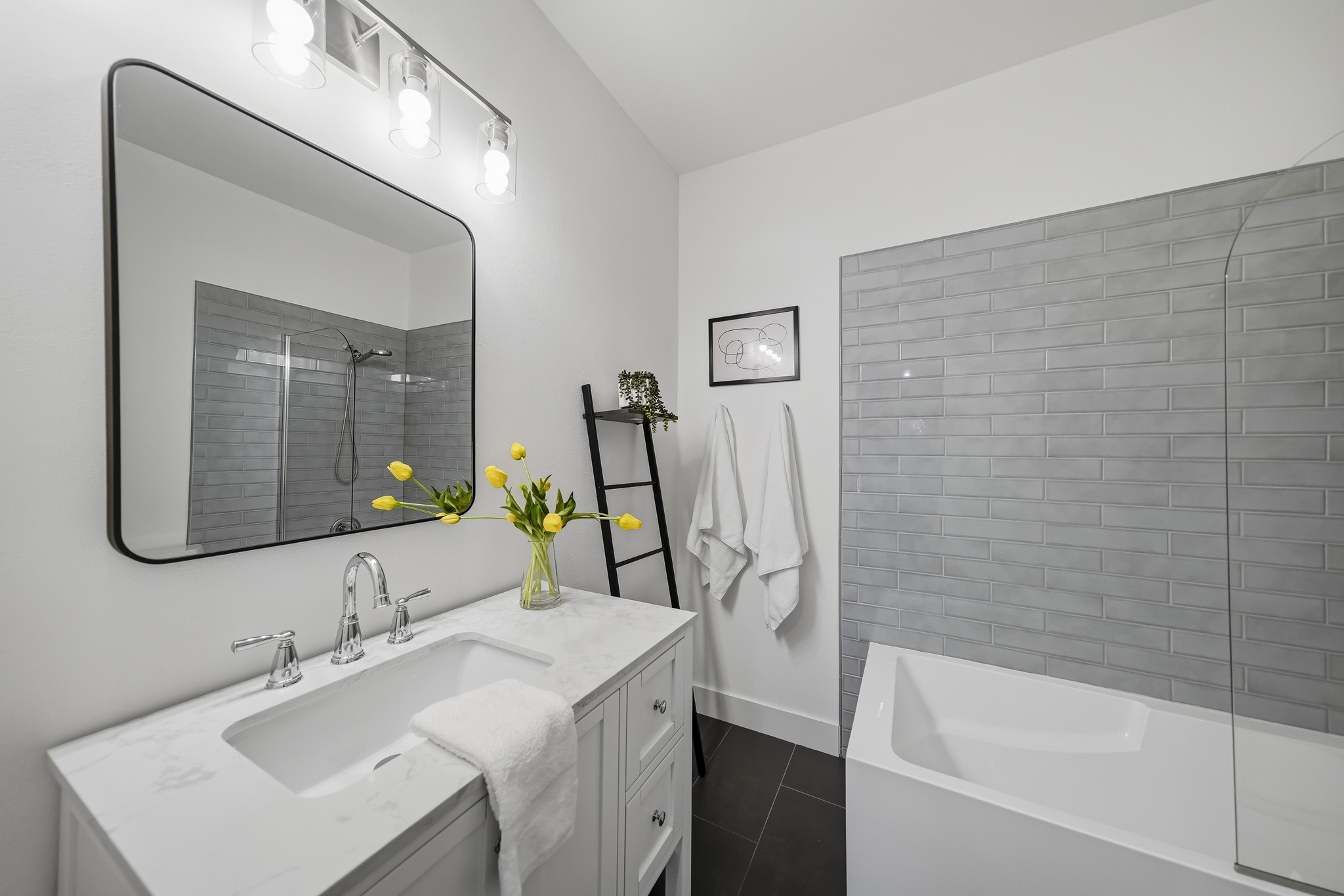 The first-floor ensuite bath was remodeled in 2024 and features elegant tile flooring and a furniture-style vanity topped with a Quartz counter, blending timeless style with modern sophistication.