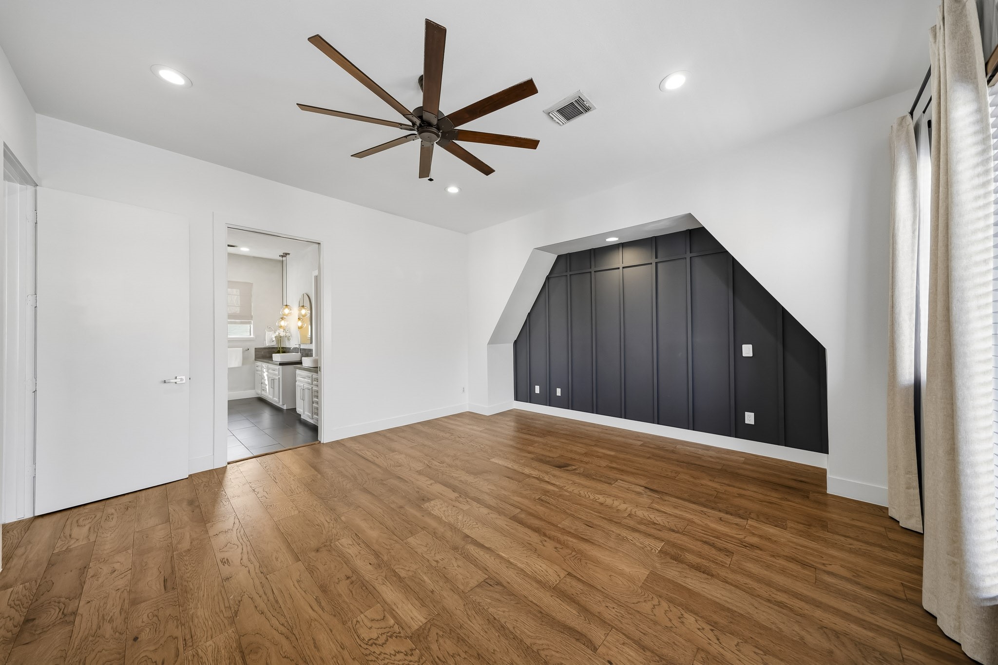 Another view of the spacious third-floor primary suite highlights the elegant design and seamless access to the private en-suite bath, creating a beautifully connected retreat.