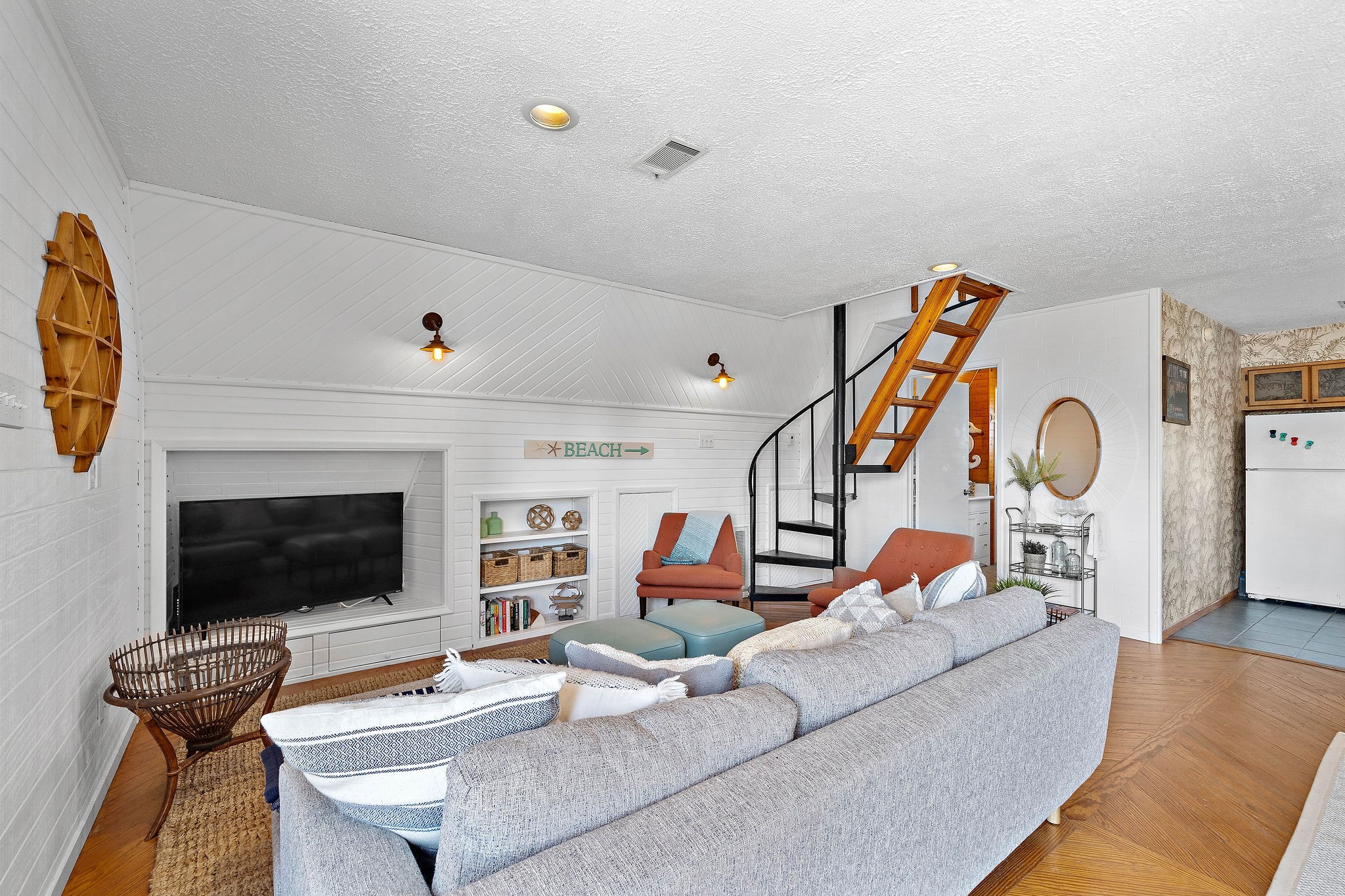 Charming living room with cozy seating, a spiral staircase, and built-in shelving, perfect for relaxing and entertaining. Charming living room with cozy seating, a spiral staircase, and built-in shelving, perfect for relaxing and entertaining.