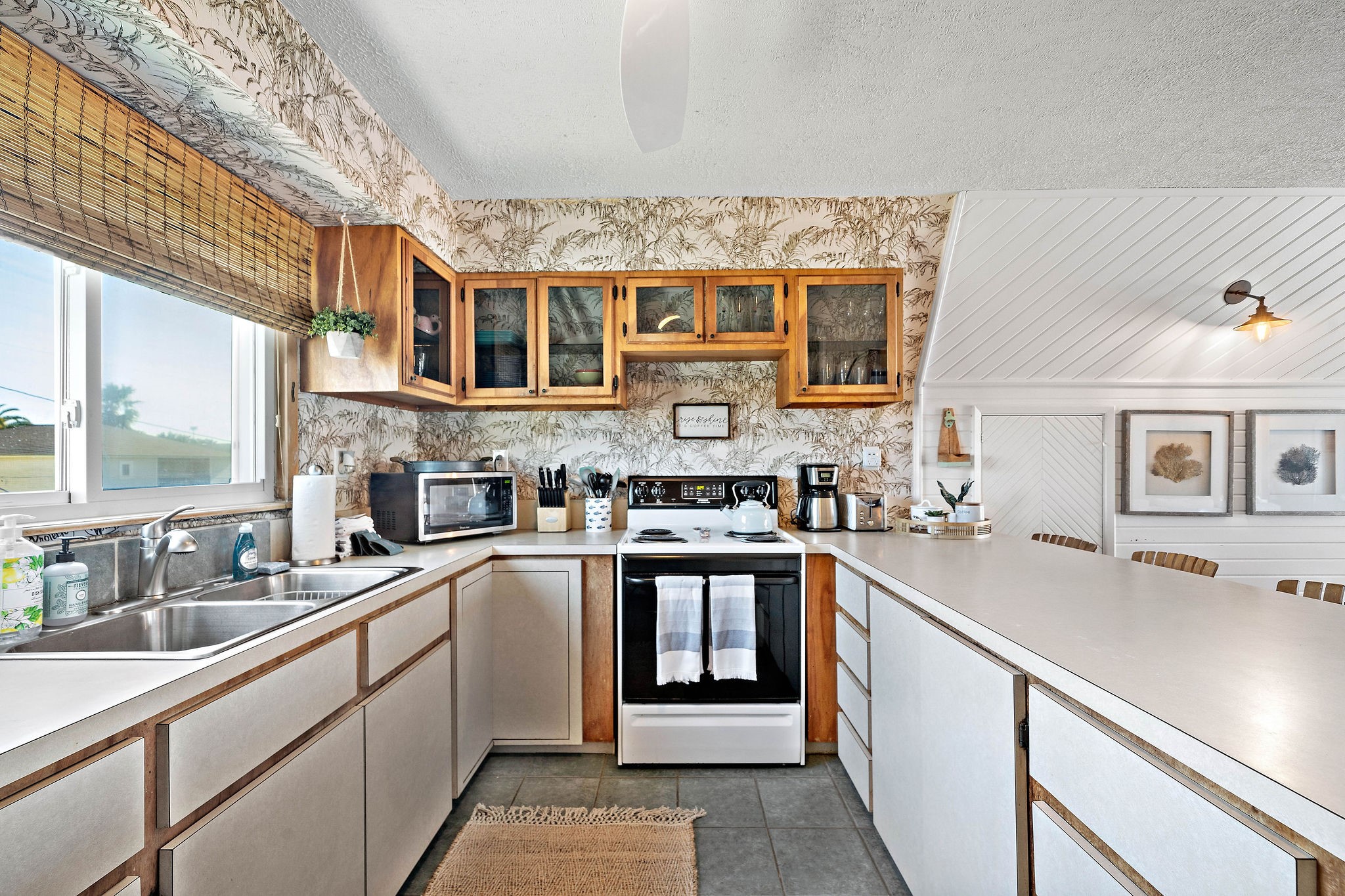 Charming kitchen with vintage wallpaper, wood accents, and ample counter space. Enjoy natural light from well-placed windows and a cozy dining nook.