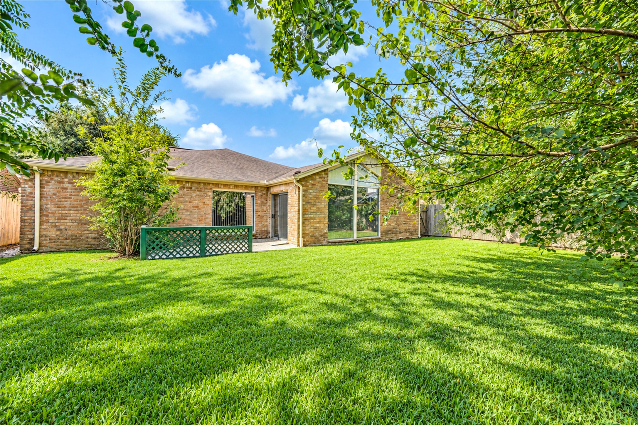 Spacious backyard with lush green lawn and mature trees, offering a private and serene outdoor space ideal for relaxation and entertaining.