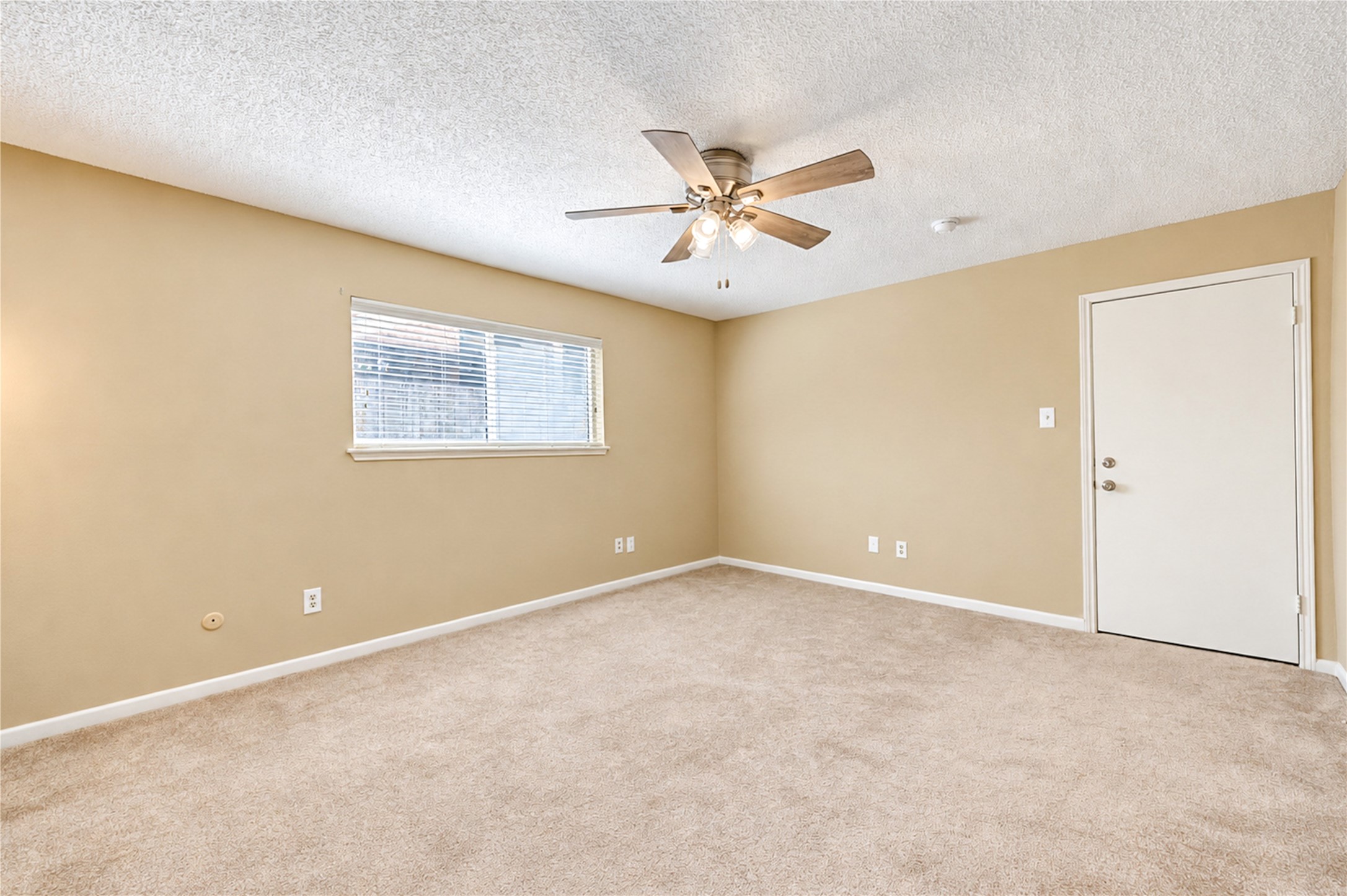 Spacious secondary bed room with soft carpet flooring, a brand new ceiling fan for comfort, and ample natural light through a large window.