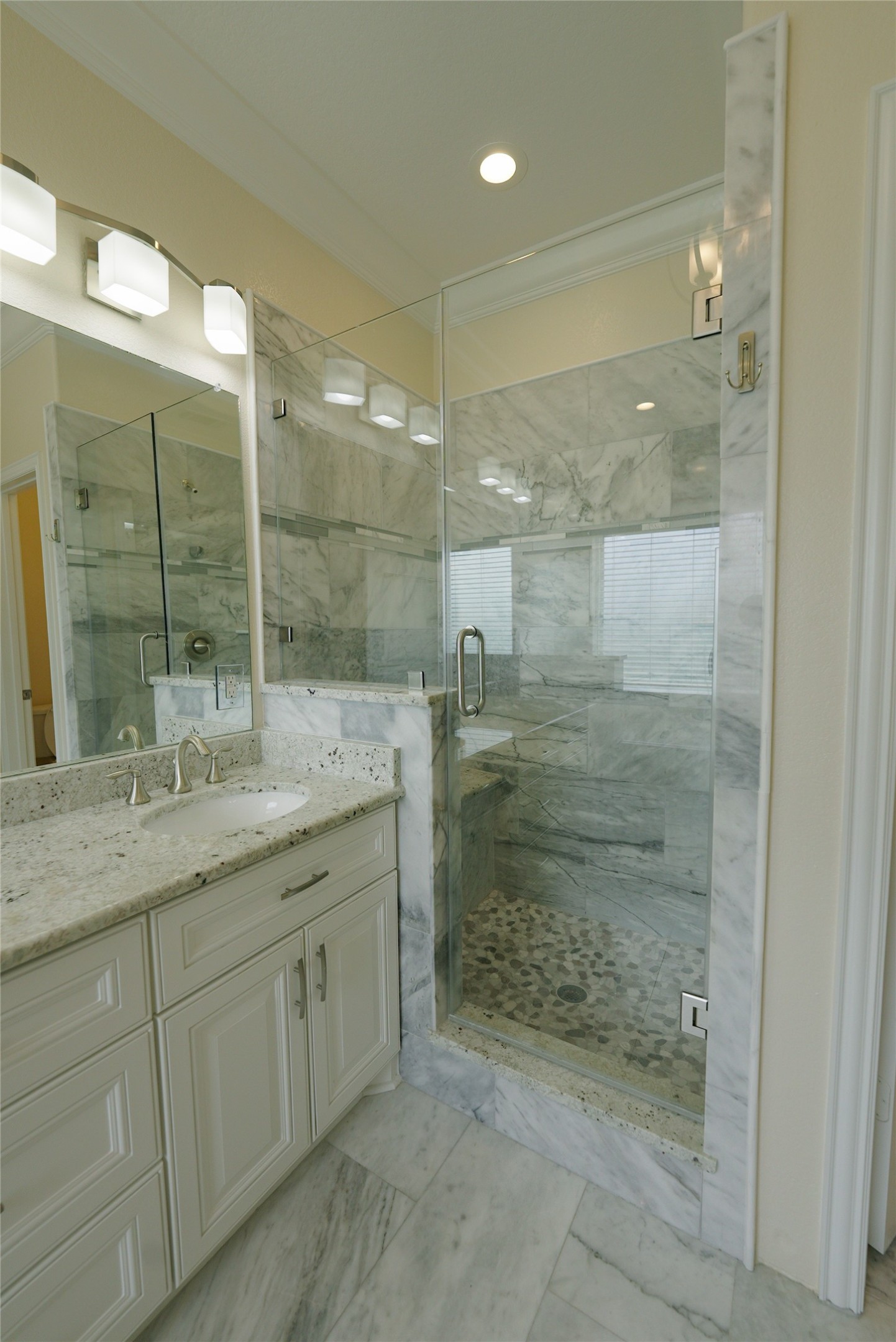 Luxurious top-level primary bathroom featuring a double vanity, jetted tub, elegant marble finishes, and recessed lighting. Currently tenant occupied.