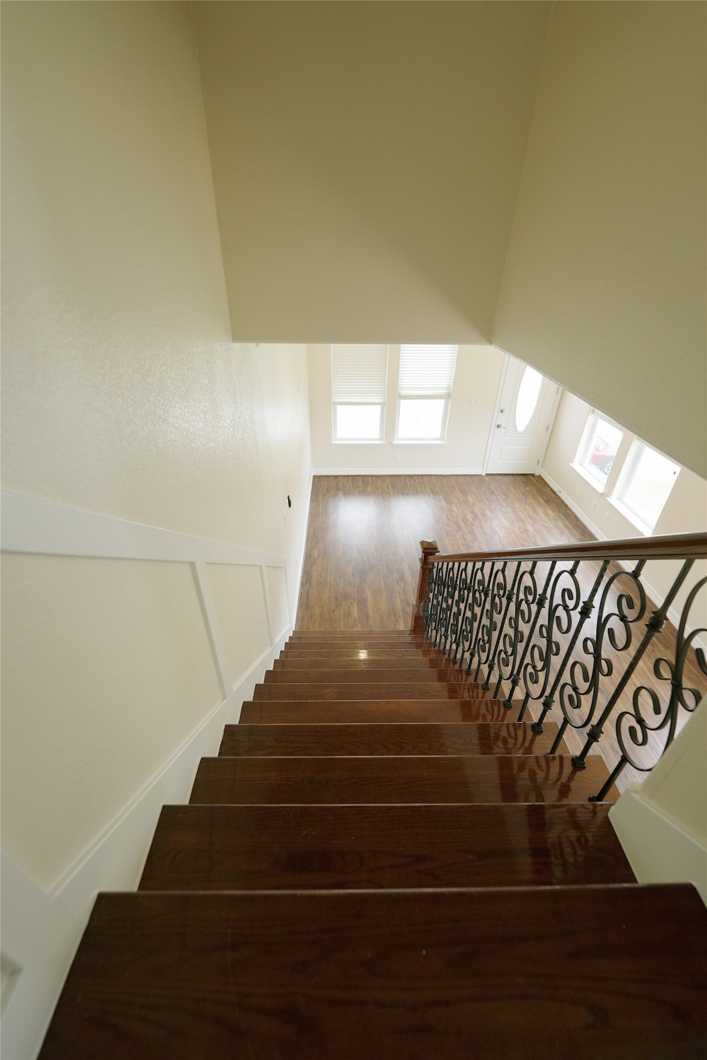 Elegant iron railing graces the staircase, leading down to the spacious second level.