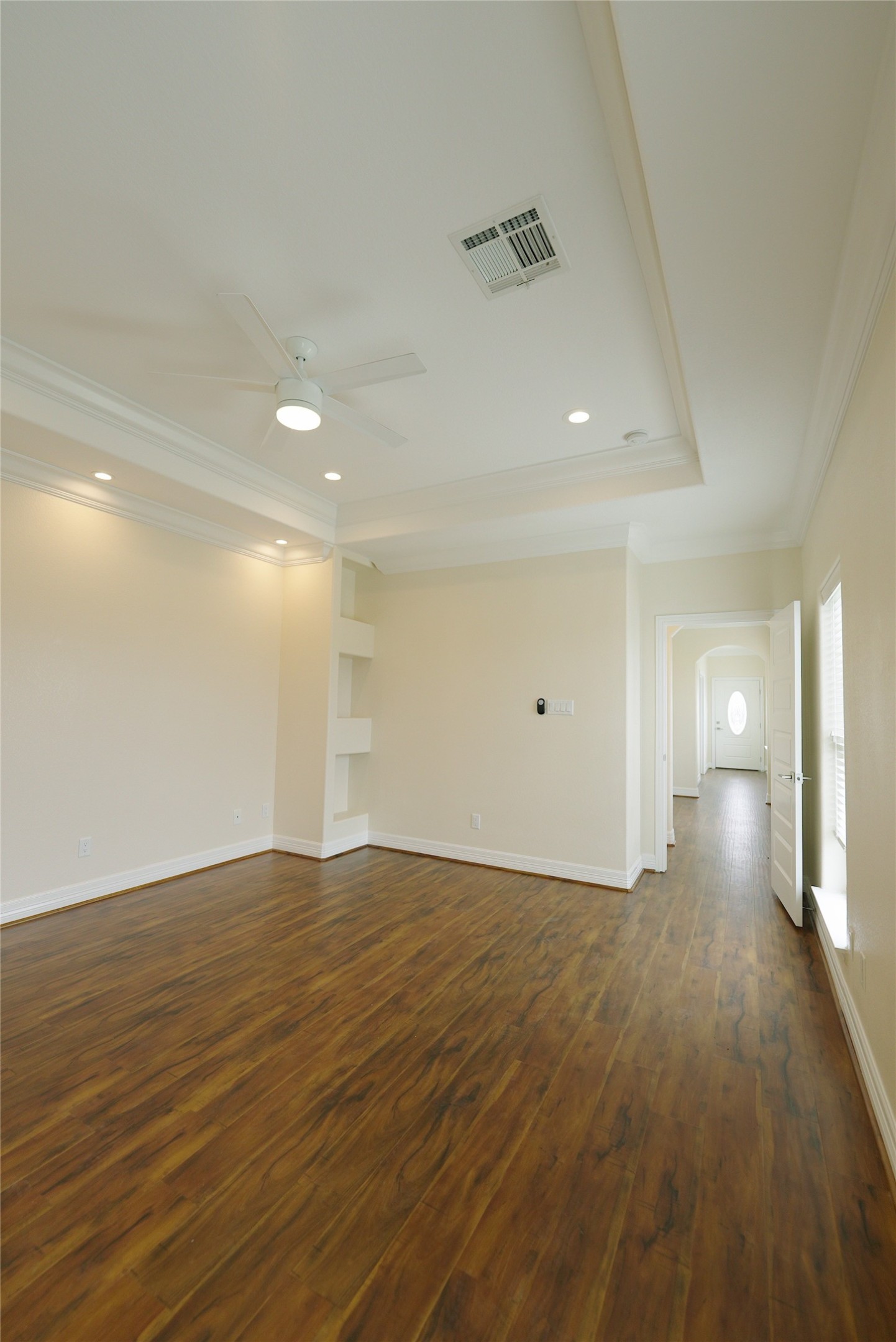 Luxurious top-level primary bedroom featuring elegant recessed lighting and stunning hardwood floors.
