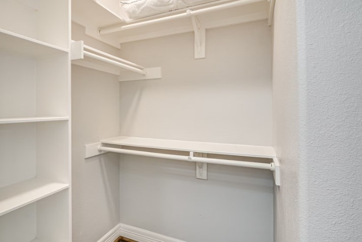 Spacious walk-in closet with ample shelving and hanging space, perfect for organizing your wardrobe.