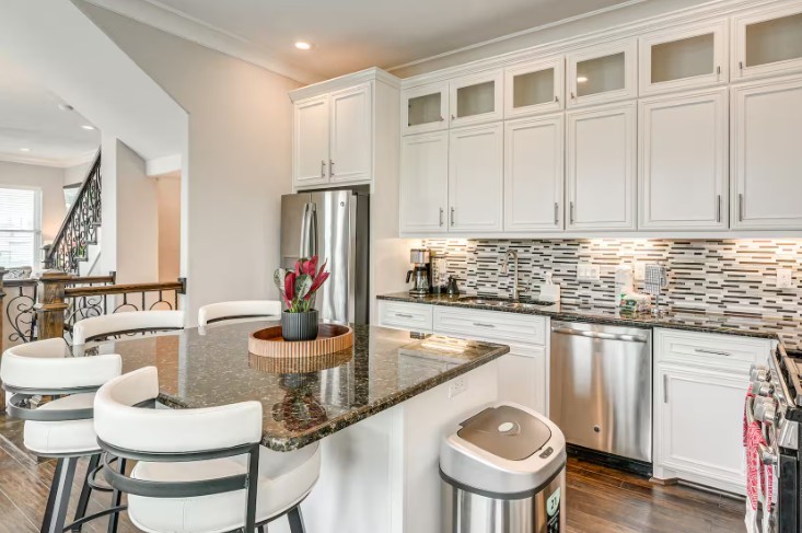 Elegant and fully furnished kitchen featuring sleek cabinetry, modern appliances, and a spacious island with seating, perfect for cooking and entertaining.