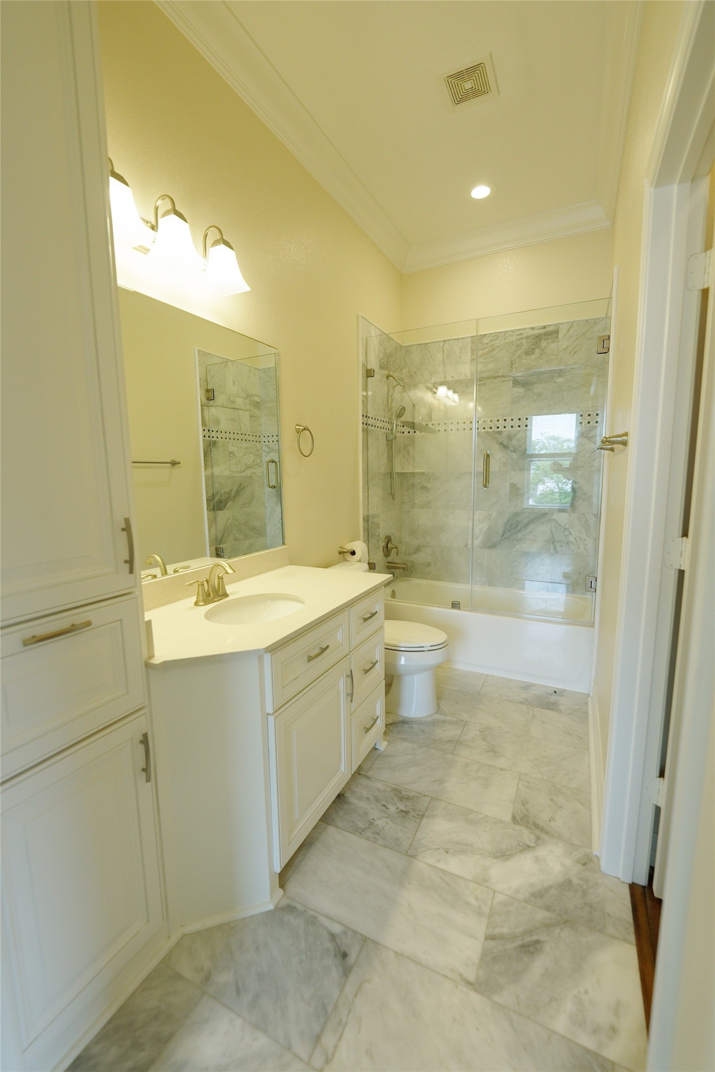 Luxurious guest bathroom featuring elegant marble finishes and modern recessed lighting. Currently tenant occupied.