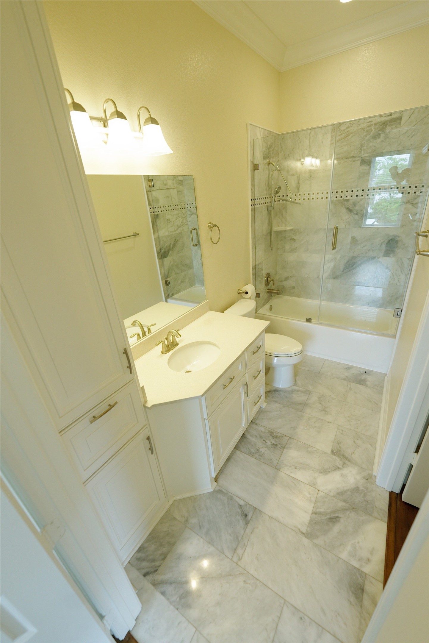 Elegant guest bathroom with marble flooring and a modern shower, currently tenant occupied.