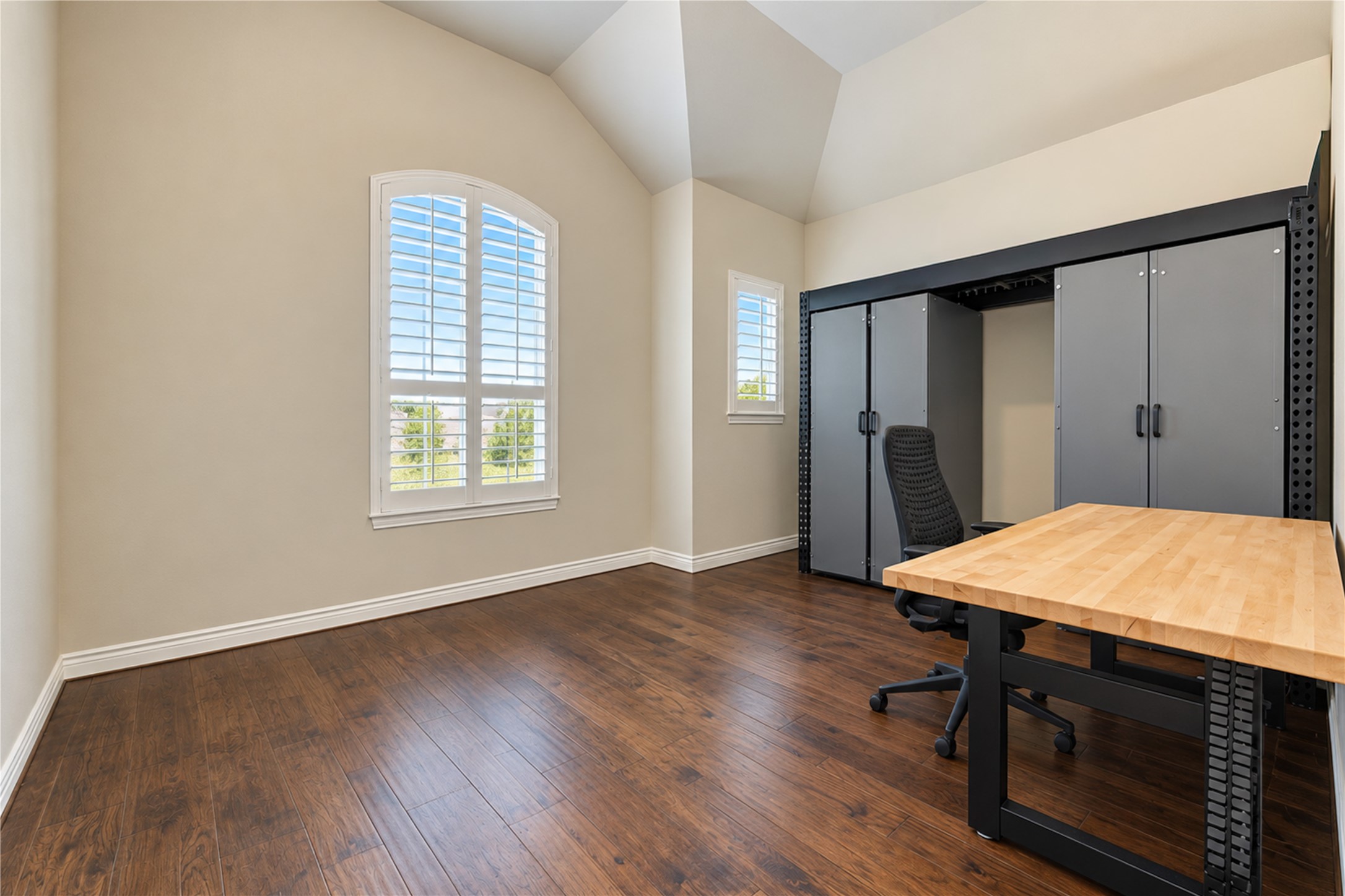 The first-floor office features soaring vaulted ceilings, north-facing windows with plantation shutters, and plenty of room to spread out and work comfortably!
