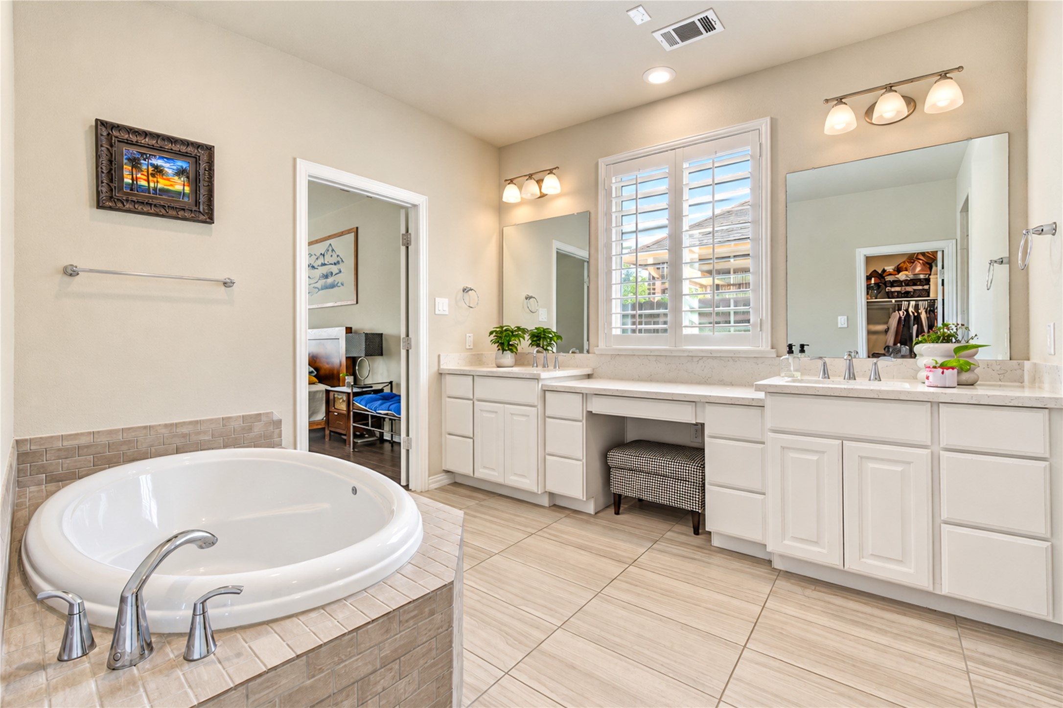 The spacious primary bath features a relaxing soaking tub, a walk-in tile shower, generous vanity space, and dual sinks, creating a comfortable retreat for everyday living.