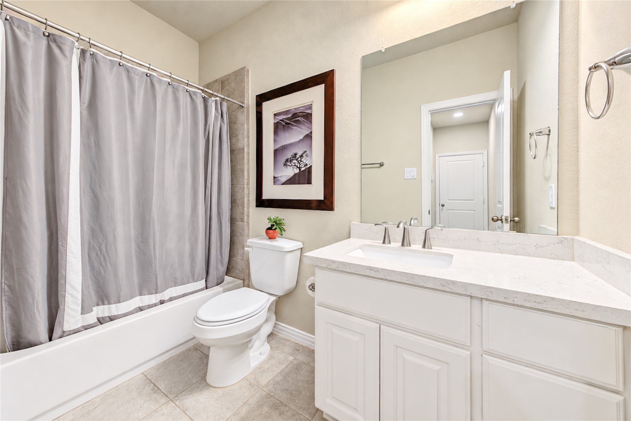 The first-floor bathroom is privately tucked away along a hallway near the downstairs secondary bedroom, offering added convenience and privacy for guests.