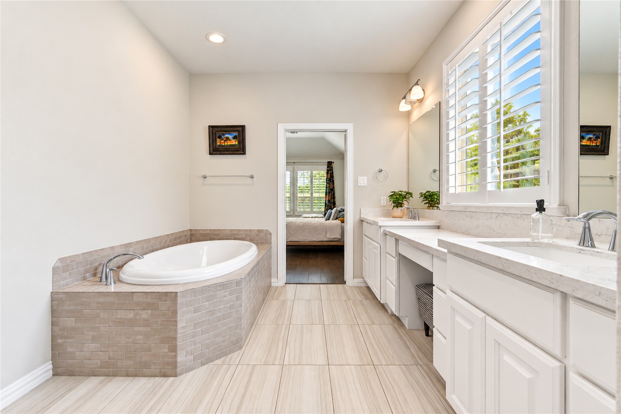The spacious primary bath features a relaxing soaking tub, a walk-in tile shower, generous vanity space, and dual sinks, creating a comfortable retreat for everyday living.