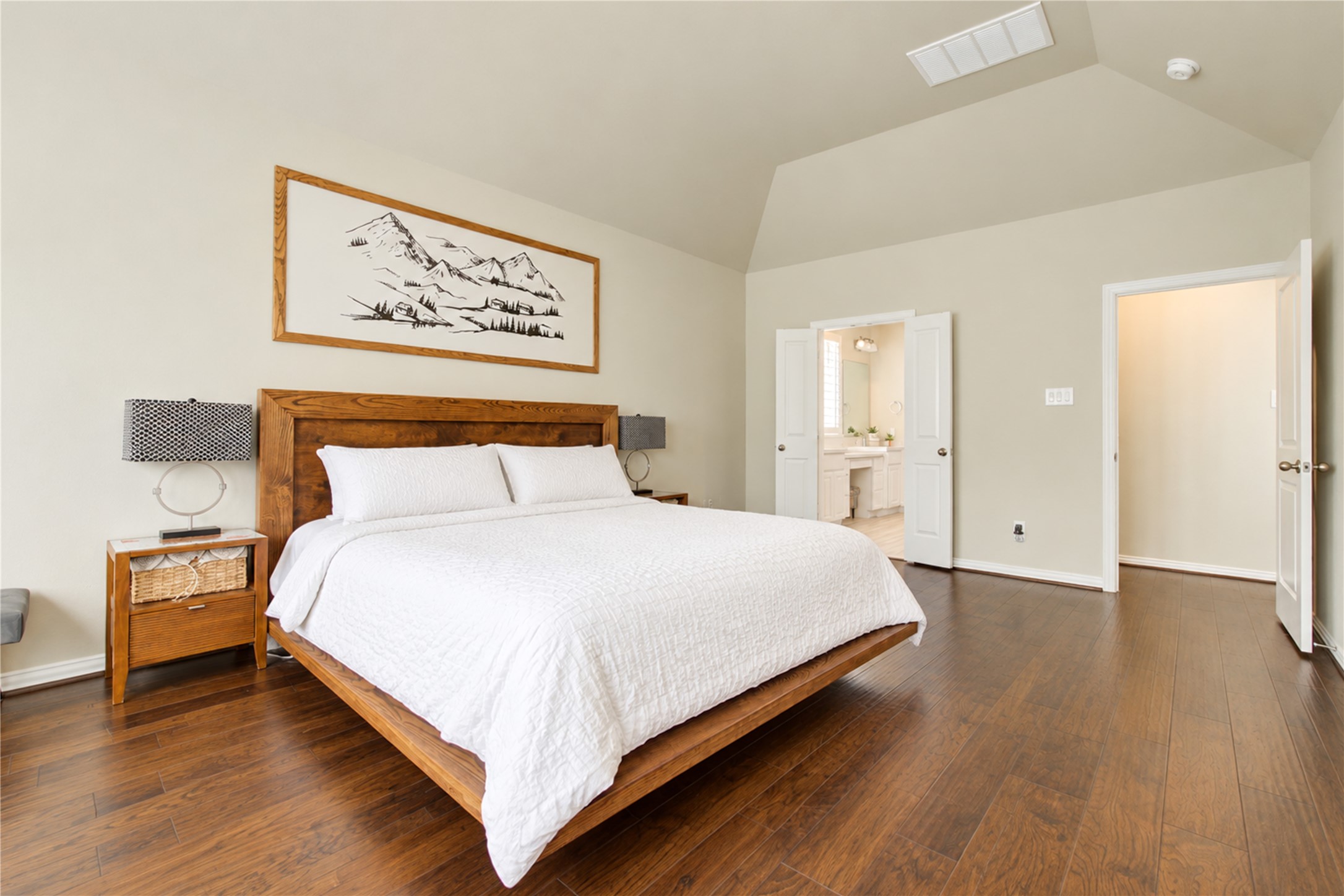 The first-floor primary suite offers peaceful backyard views, soaring vaulted ceilings, and abundant space to accommodate a king-sized bedroom set along with a comfortable sitting area.