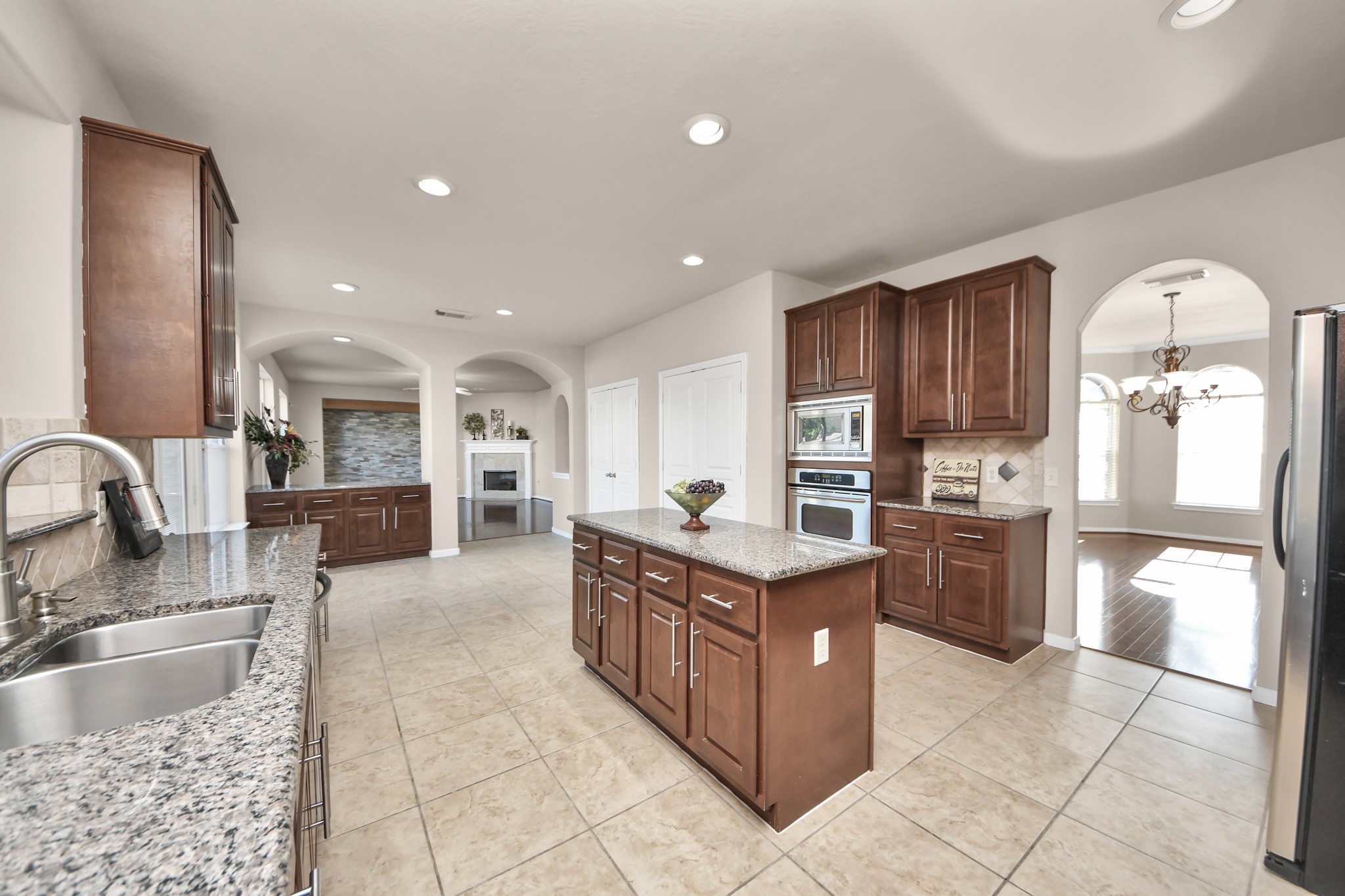 The spacious island kitchen flows seamlessly into the formal dining room, breakfast area, and living space, creating an ideal layout for both everyday living and entertaining.