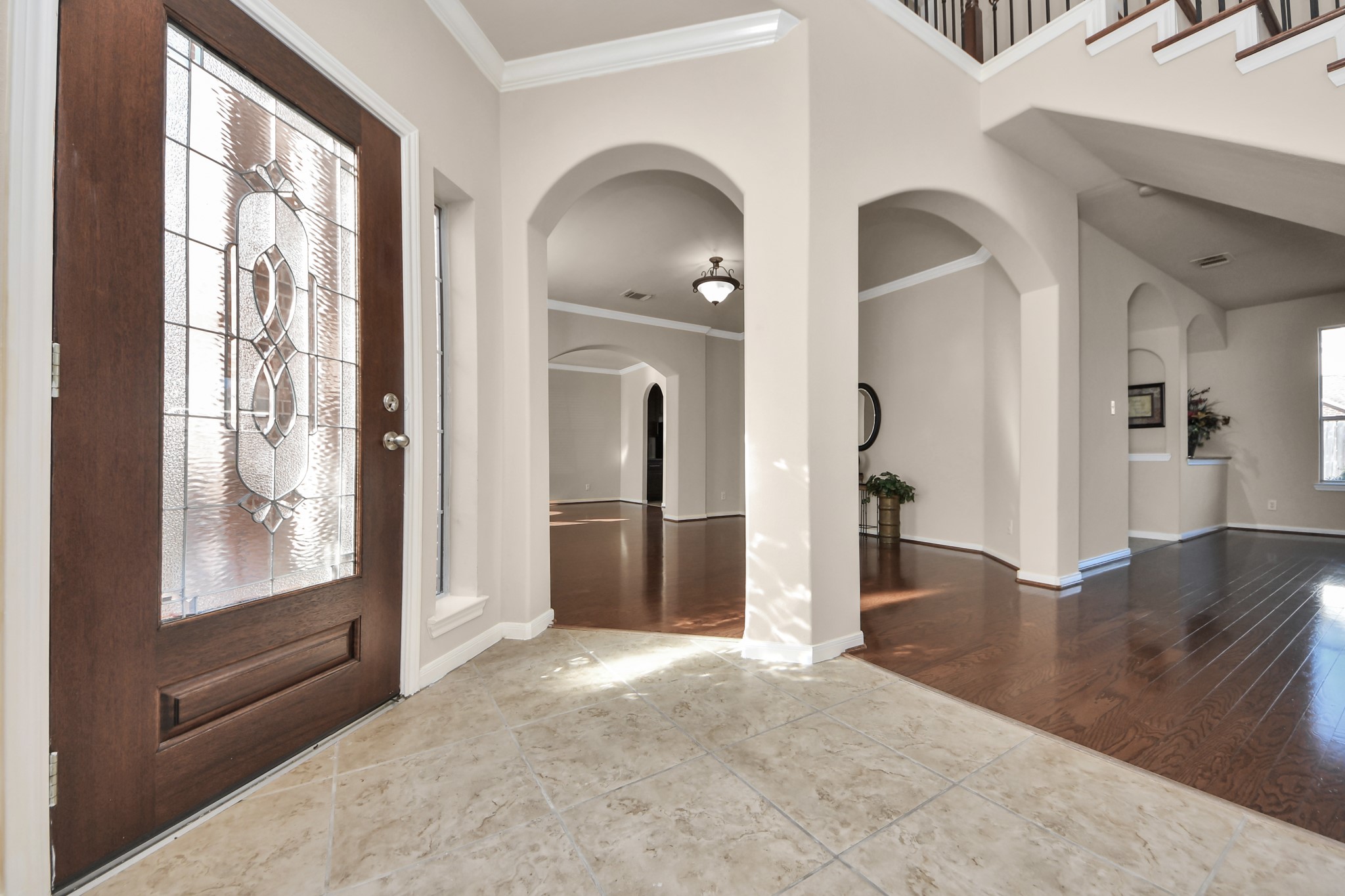 The beautiful front entry showcases Village Builders timeless architectural design, featuring elegant crown molding, rich wood flooring, graceful arches, decorative insets, and an abundance of natural light that welcomes you at every turn!