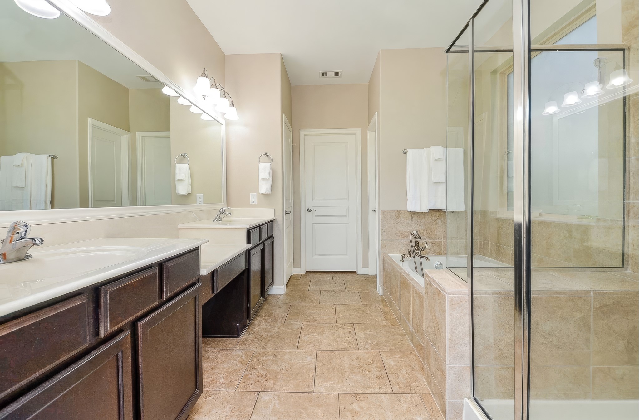 Primary bathroom leading into one of two walk-in closets.
