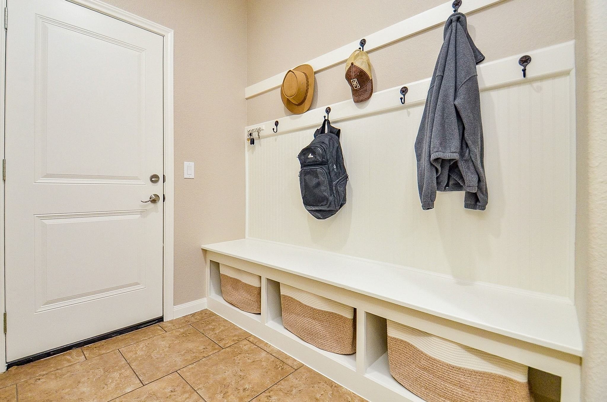 Beautifully appointed mudroom next to the garage and laundry room.