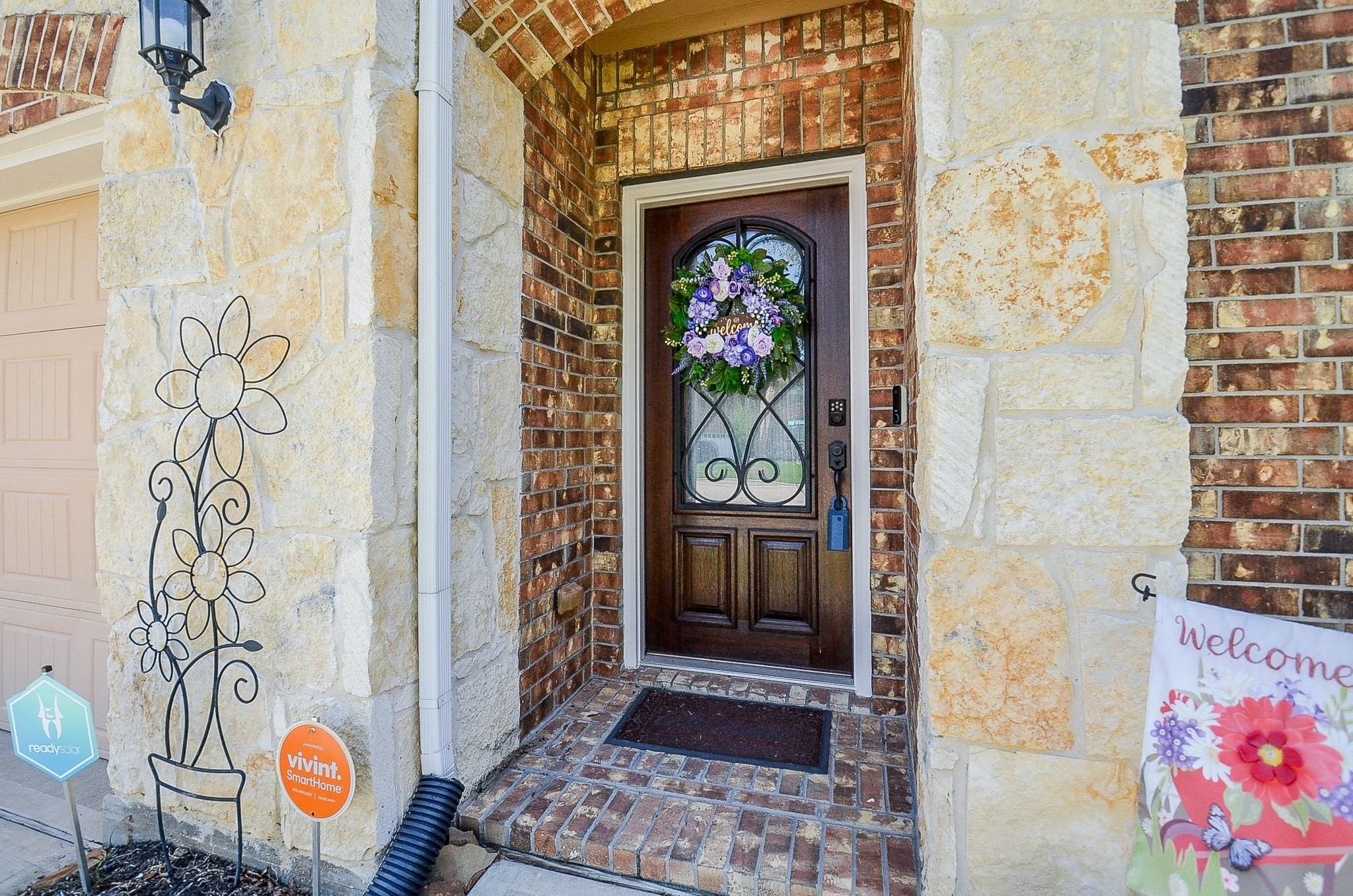 Gorgeous entry to the home with Austin Stone and a newly refinished front door complete with a glass panel and decorate wrought iron.